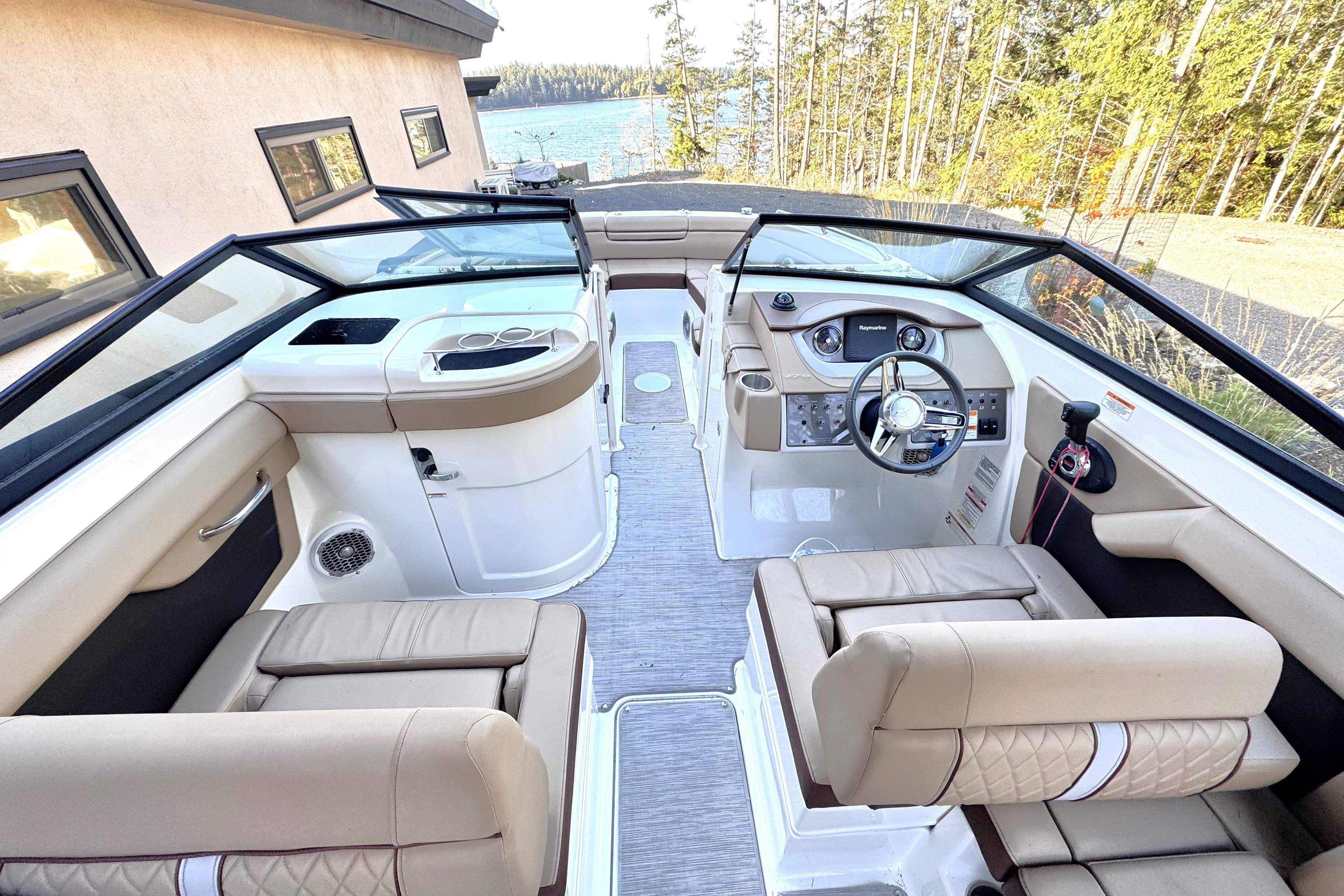 2016 Sea Ray 270 Sundeck interior with beige seating and modern dashboard.