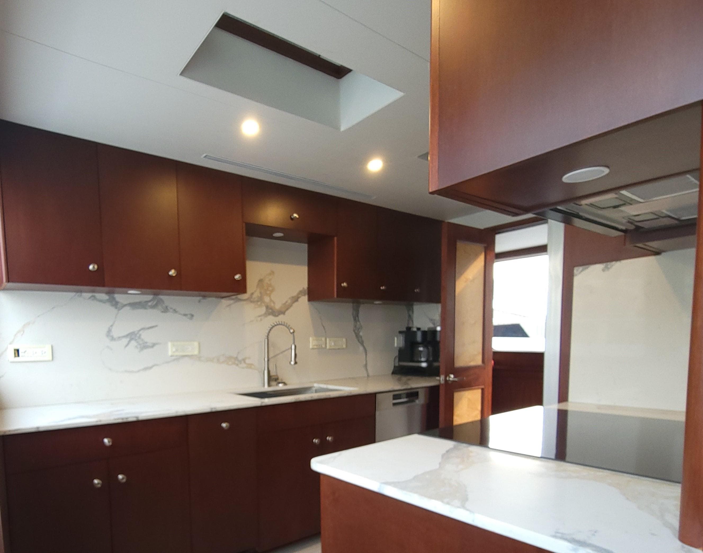 Luxurious kitchen in 2006 Cheoy Lee Motor Yacht Bravo Series with modern cabinetry and marble countertops.