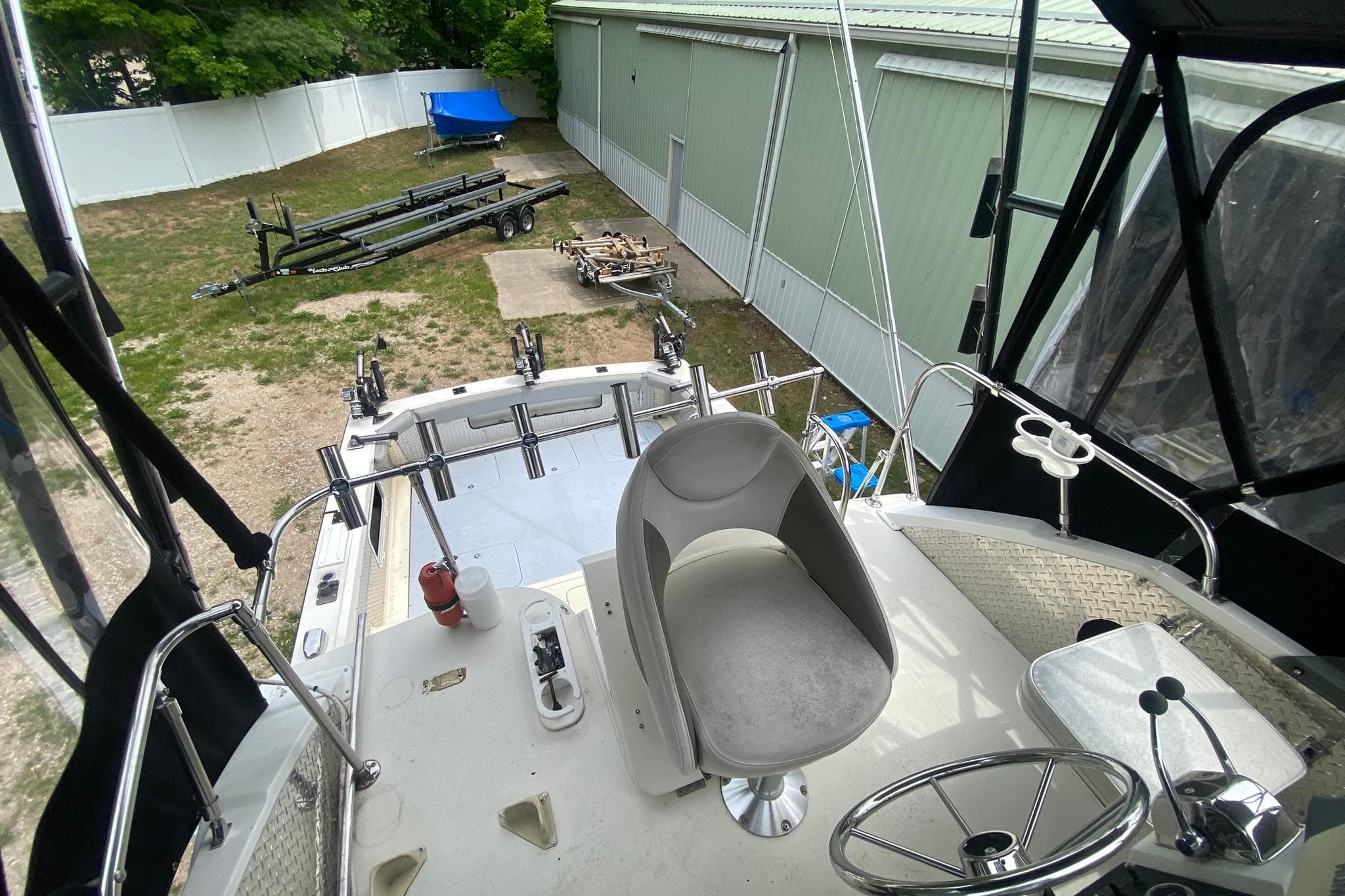 1977 Bertram 28 Flybridge boat interior with steering wheel and fishing rod holders.