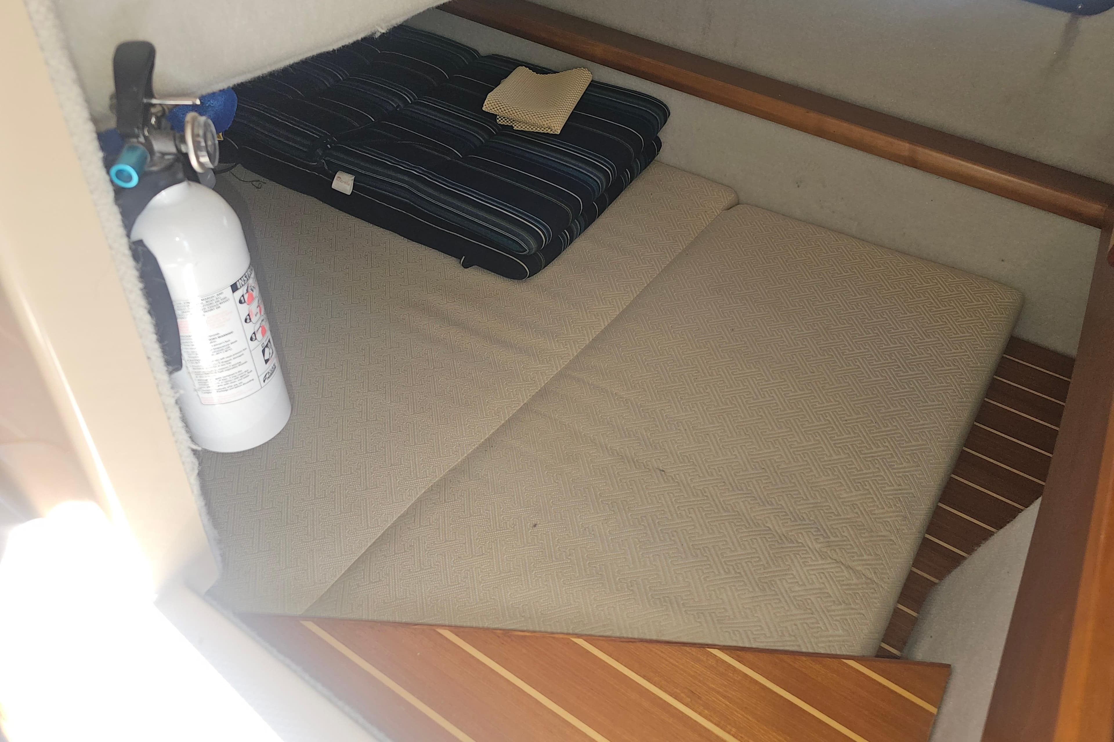 2015 Cutwater 30 Command Bridge cabin interior with fire extinguisher and bedding.