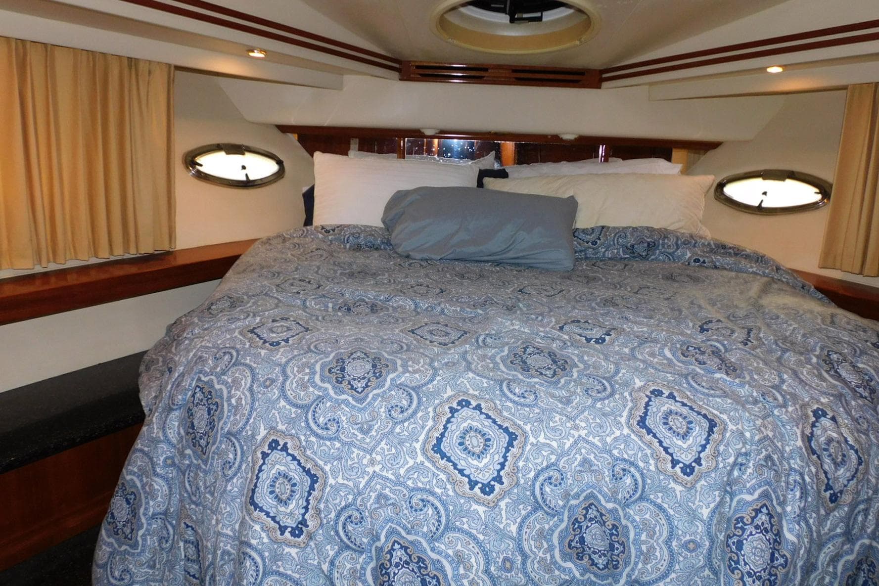 Luxurious bedroom interior of 2002 Carver 570 Voyager Pilothouse yacht with patterned bedding.