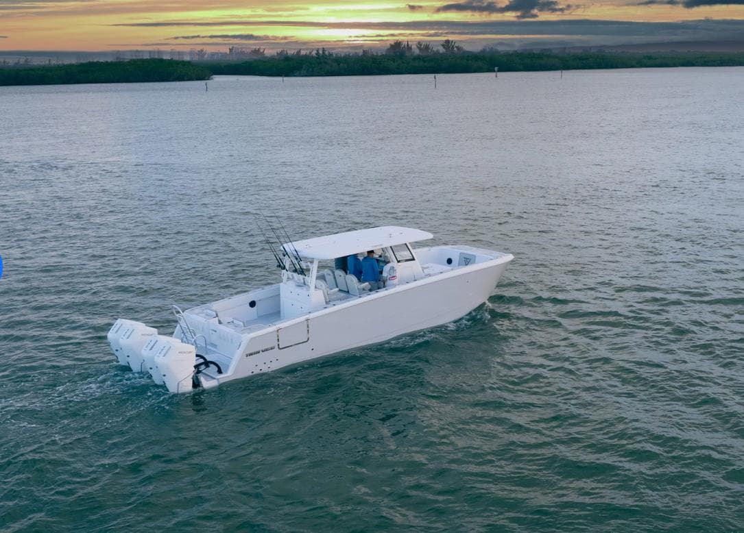 Twin Vee 400 GFX 2025 boat cruising at sunset on calm waters.