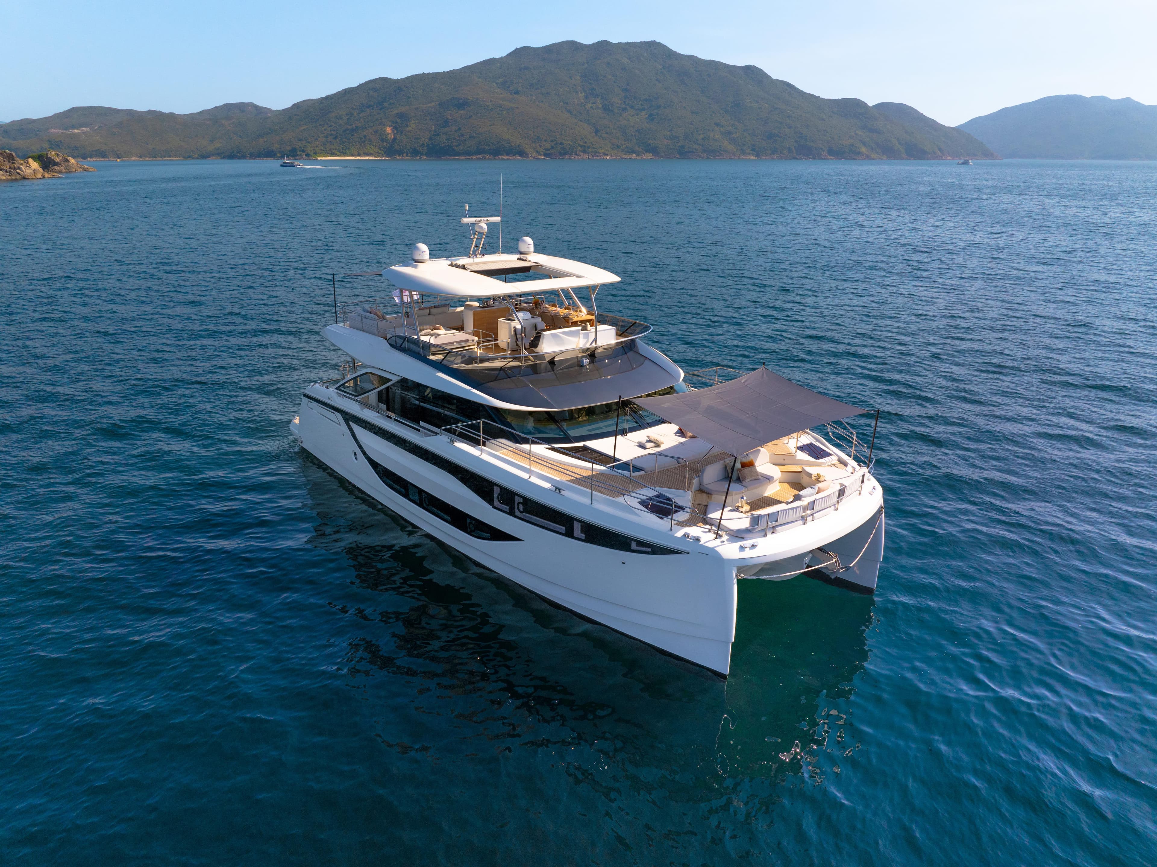 Luxury Prestige M8 yacht cruising in serene waters, 2025 model, with scenic mountain backdrop.