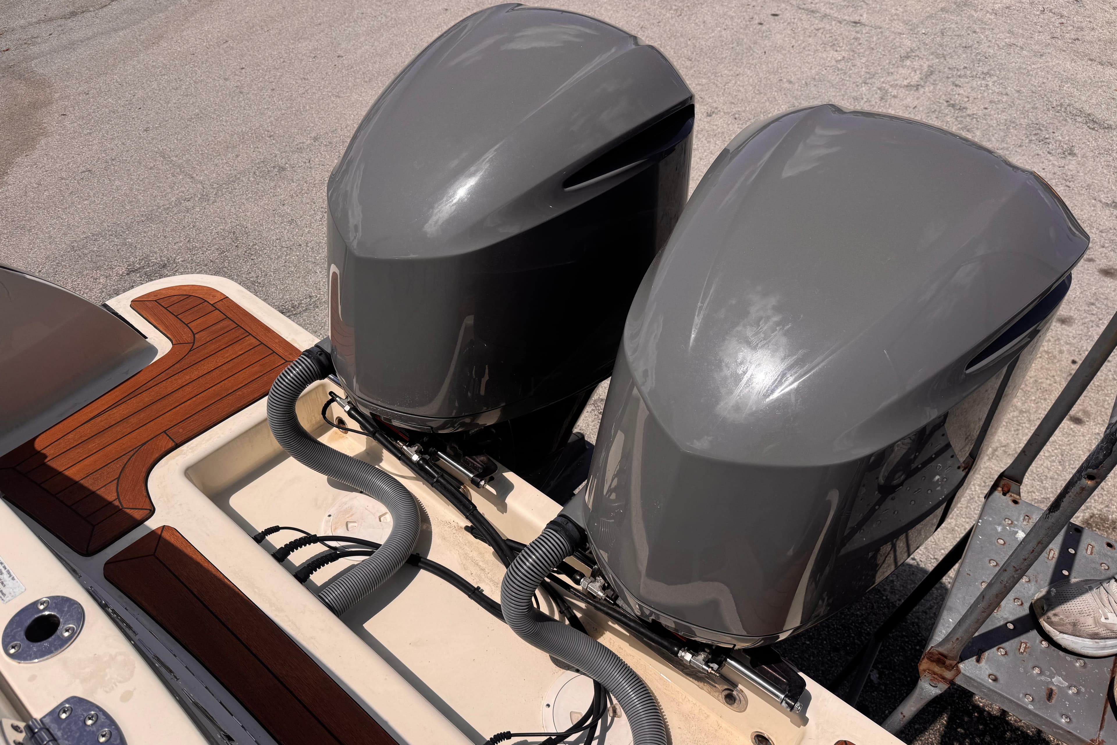 Twin outboard engines on a 2018 Chris-Craft Calypso 30 boat, docked on a sunny day.