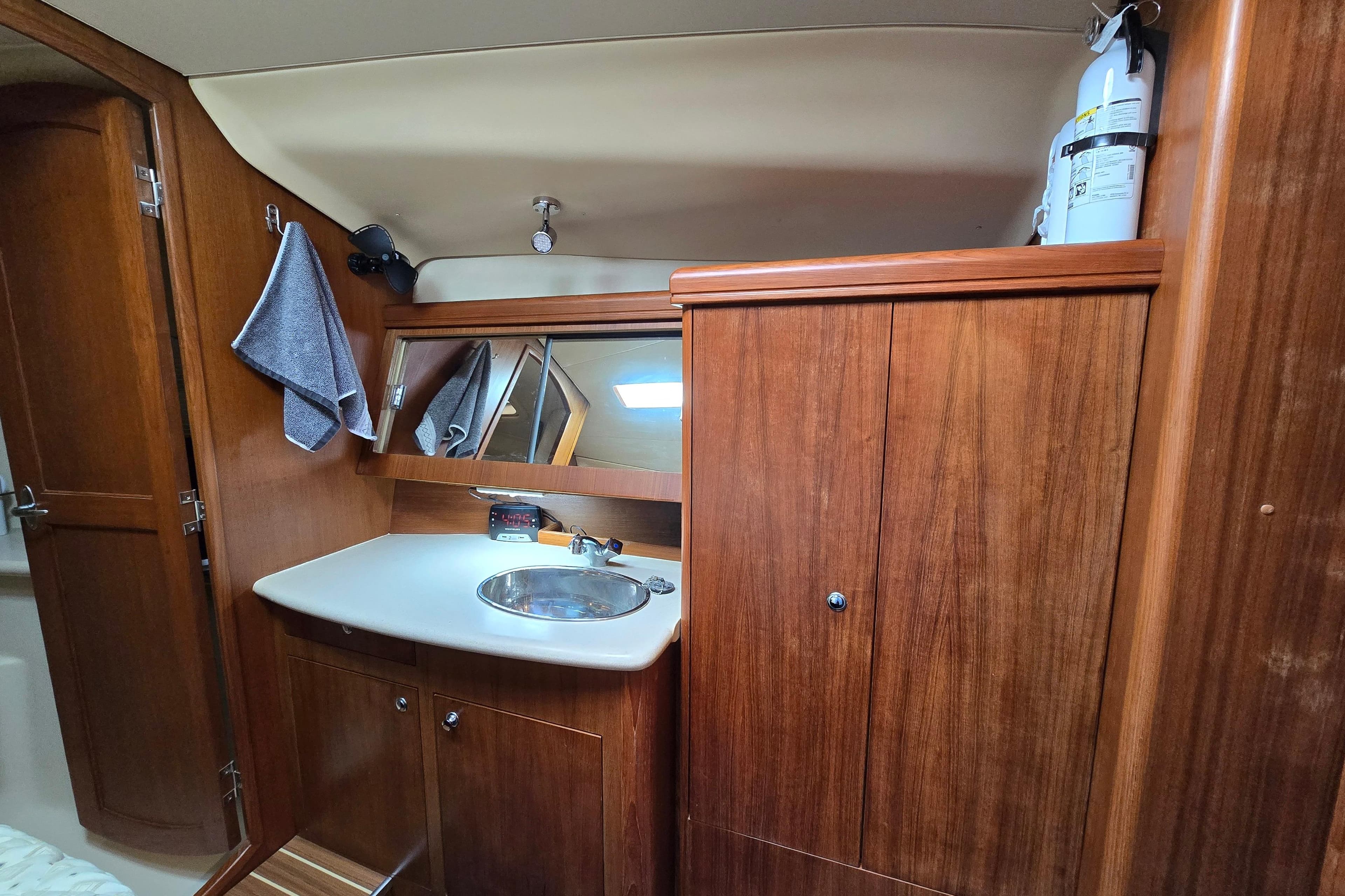 Interior of 2004 Hunter 41 AC yacht bathroom with wooden cabinetry and sink.