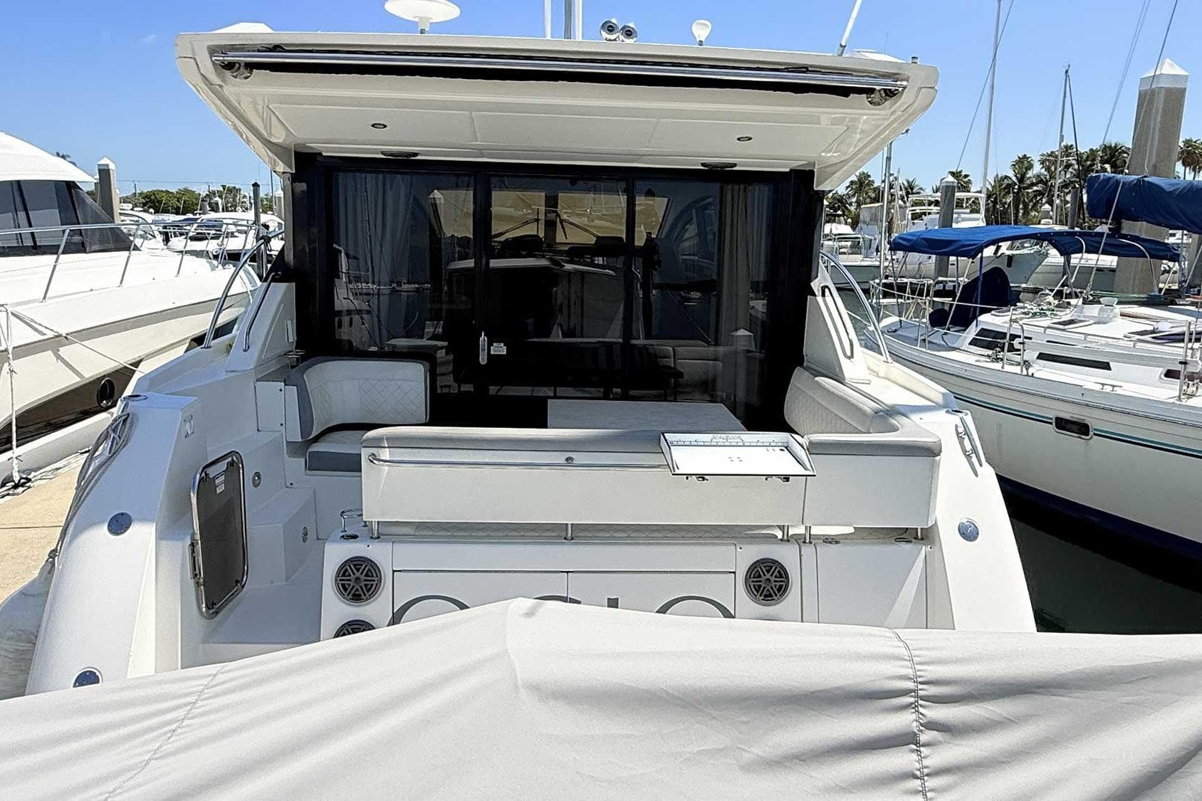 2017 Sea Ray Sundancer 400 yacht docked at marina, rear view with seating area.