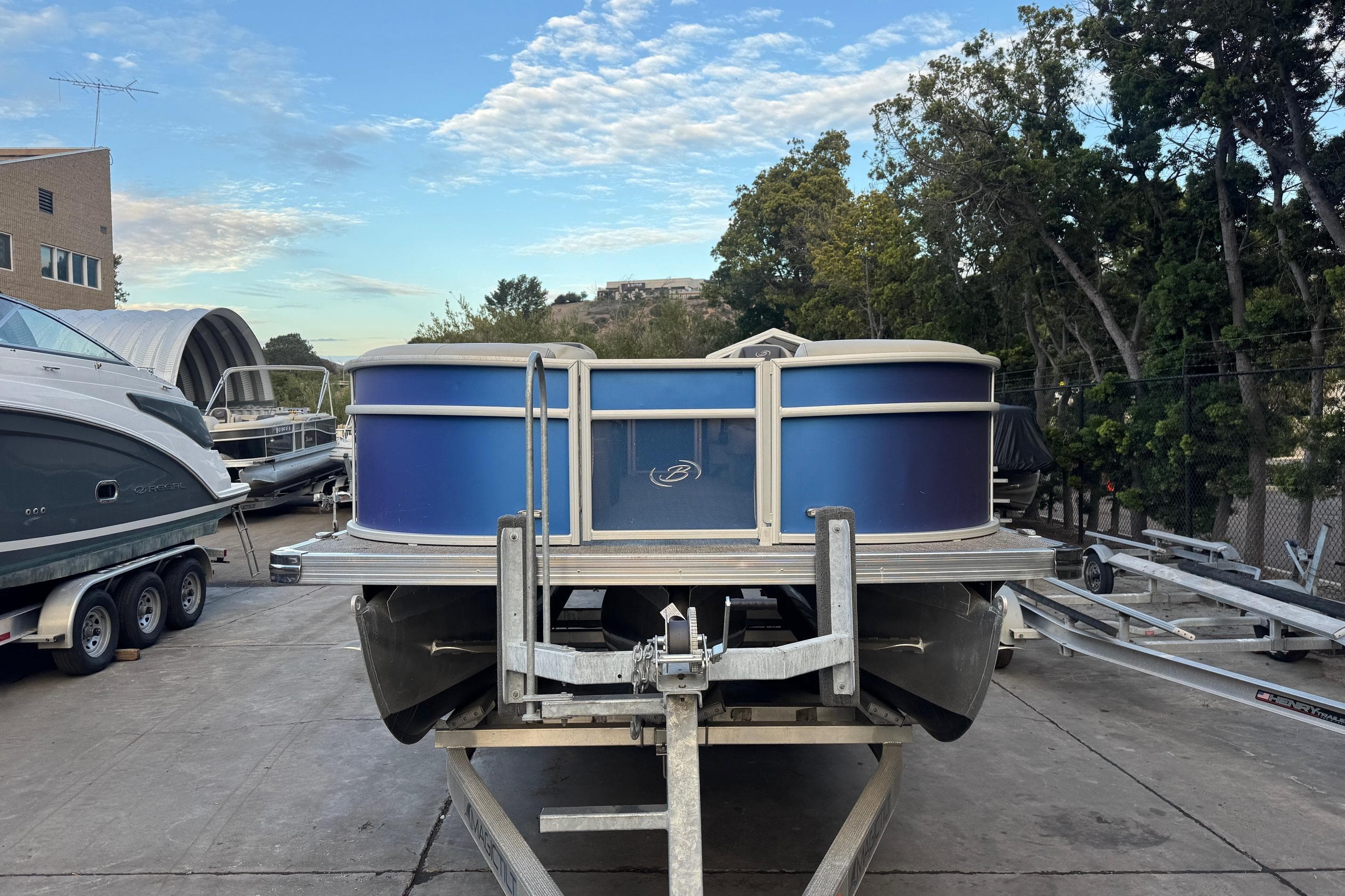 2023 Barletta ARIA 22QC pontoon boat on trailer, parked outdoors.