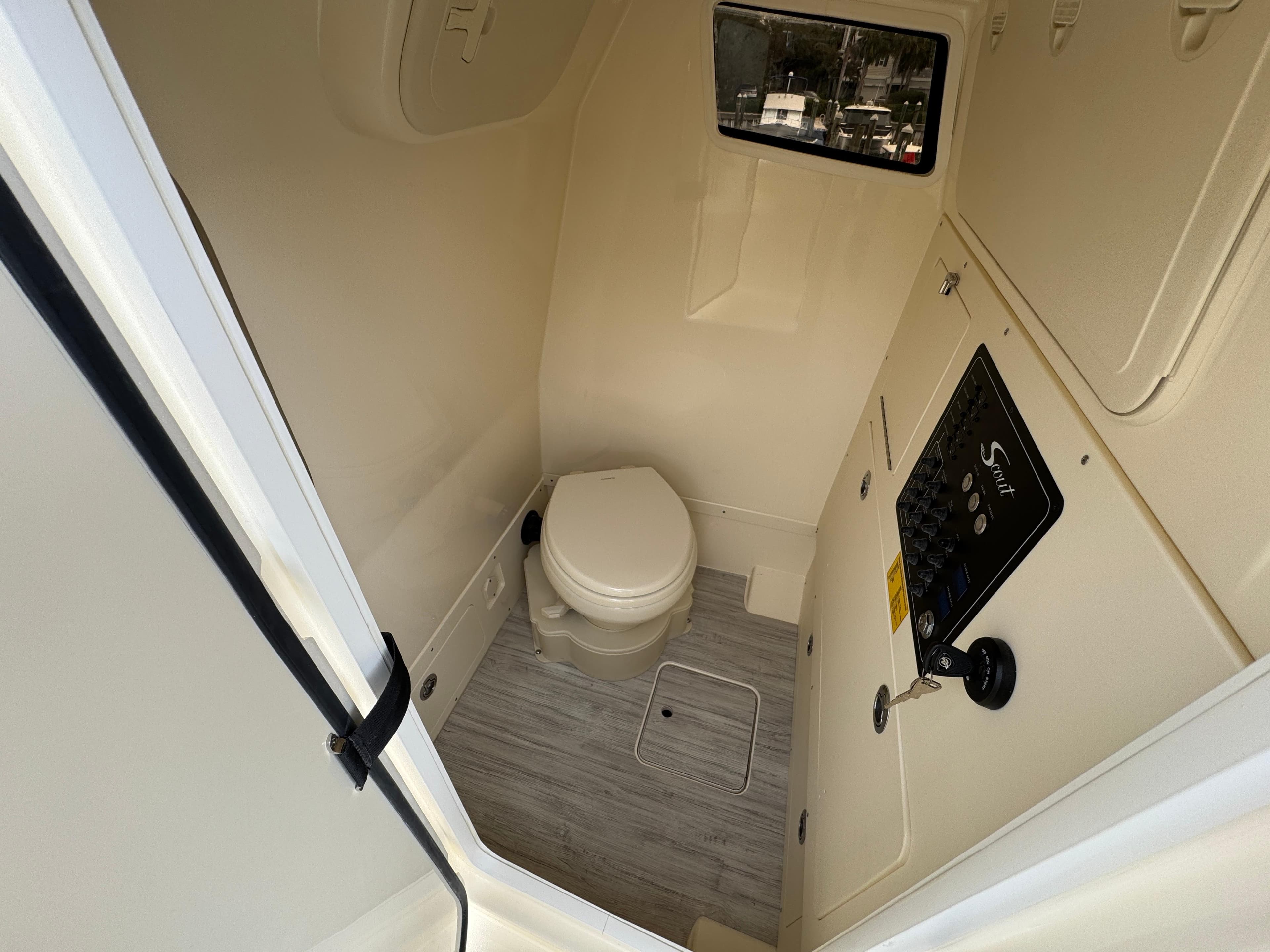 2025 Scout 261 XSS boat interior bathroom with toilet and control panel.