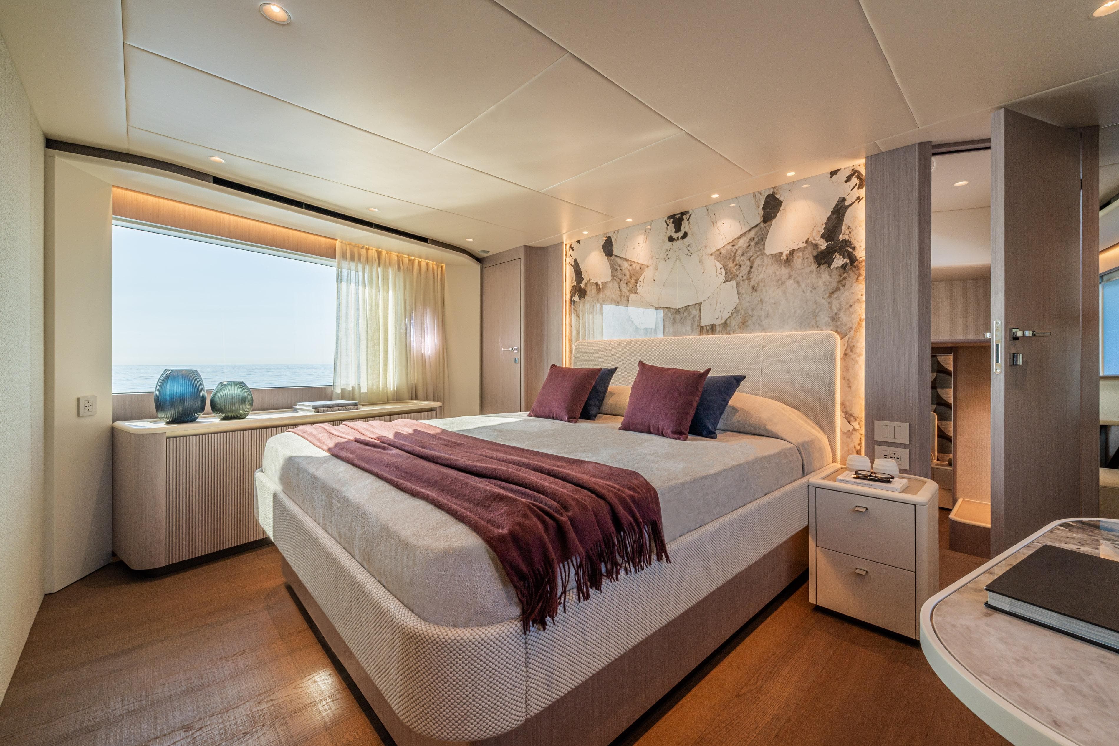 Luxurious bedroom interior on 2026 Absolute 62' Navetta yacht, featuring elegant decor and ocean view.