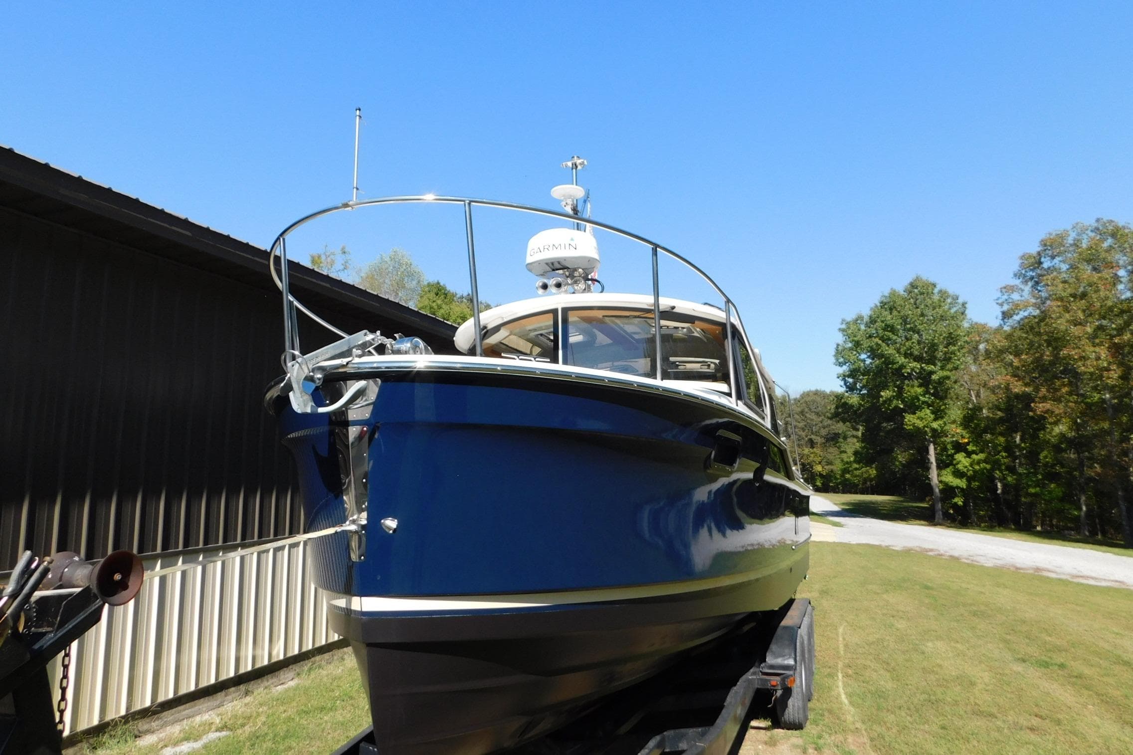 2022 Ranger Tugs R-27 boat on trailer, parked outdoors under clear blue sky.