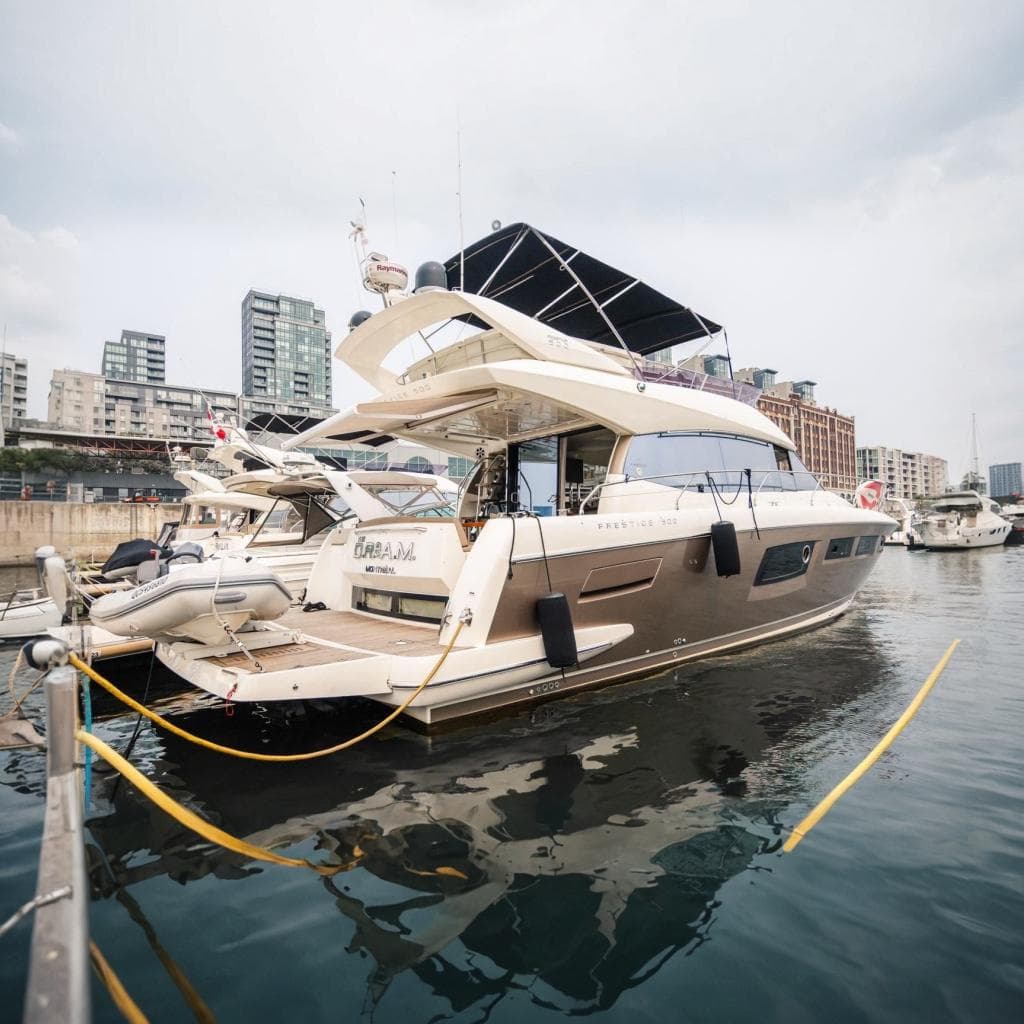 Luxurious 2015 Prestige 500 yacht docked in urban marina setting.