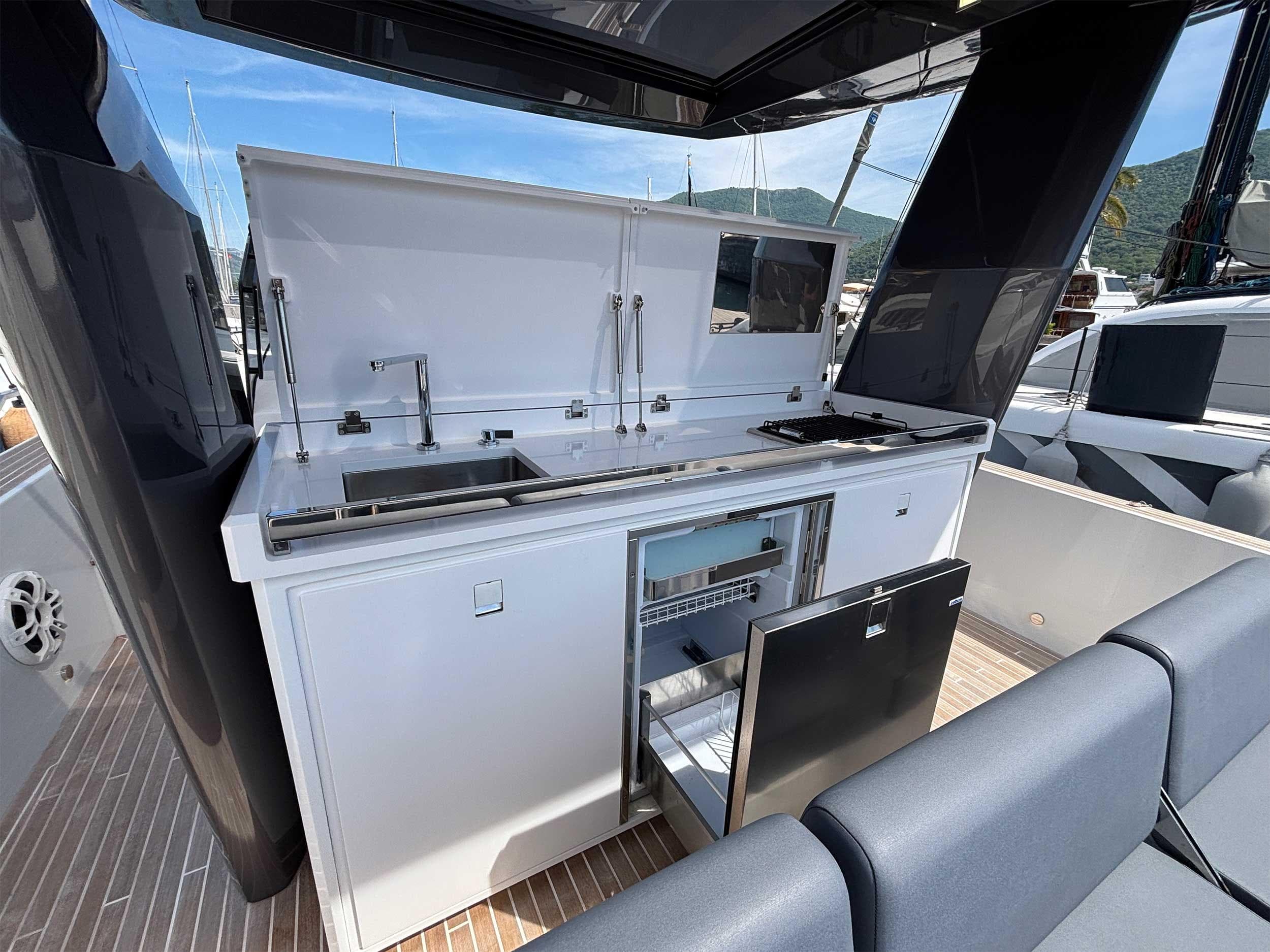Outdoor kitchen on 2024 Fiart 43 Seawalker yacht, featuring sink, grill, and storage.
