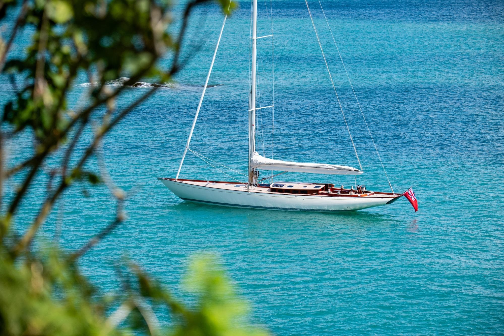 Sleek 2023 Spirit Yachts C72 sailboat on turquoise waters, framed by lush greenery.