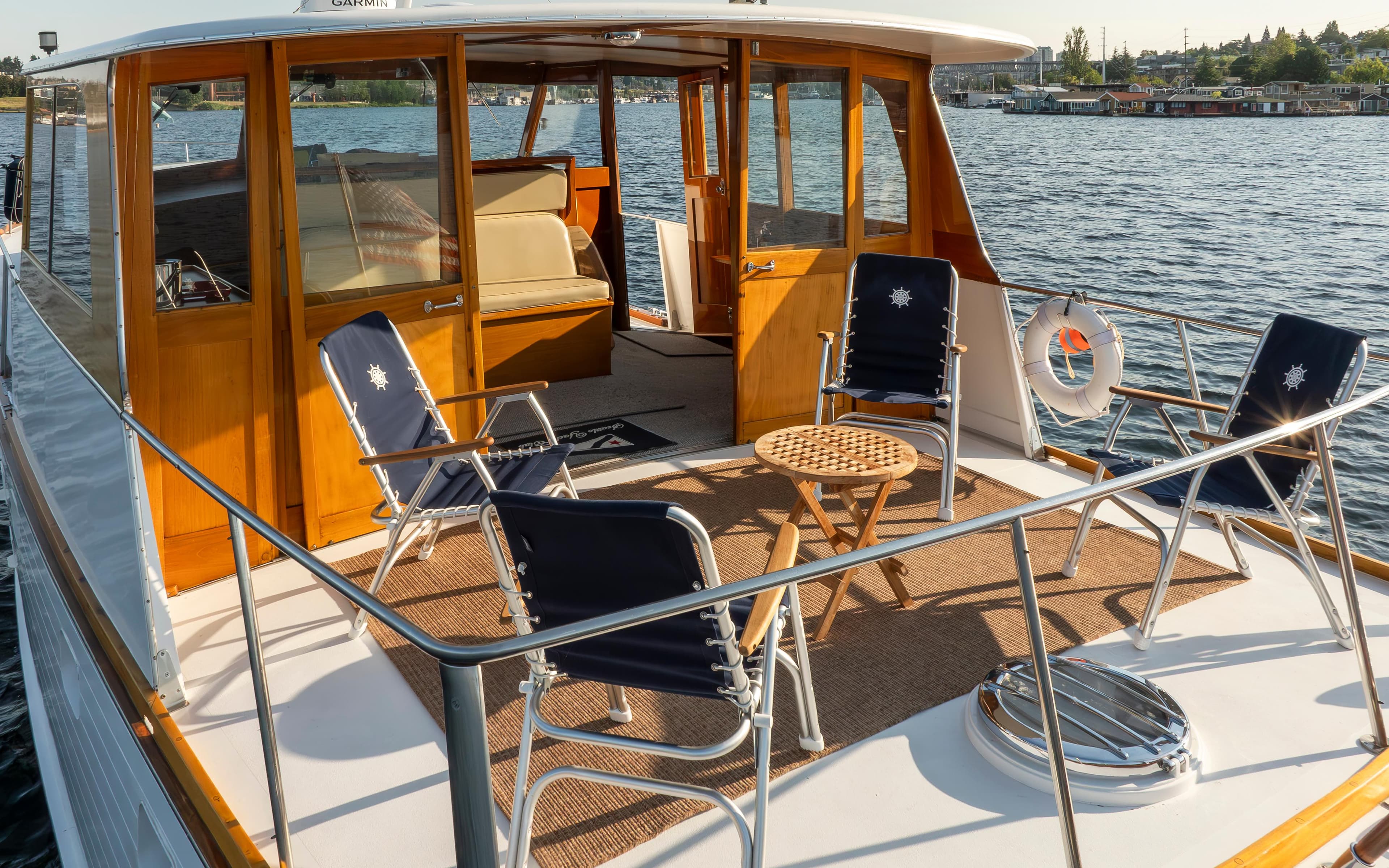 1965 Stephens Flushdeck yacht with deck furniture on calm water.