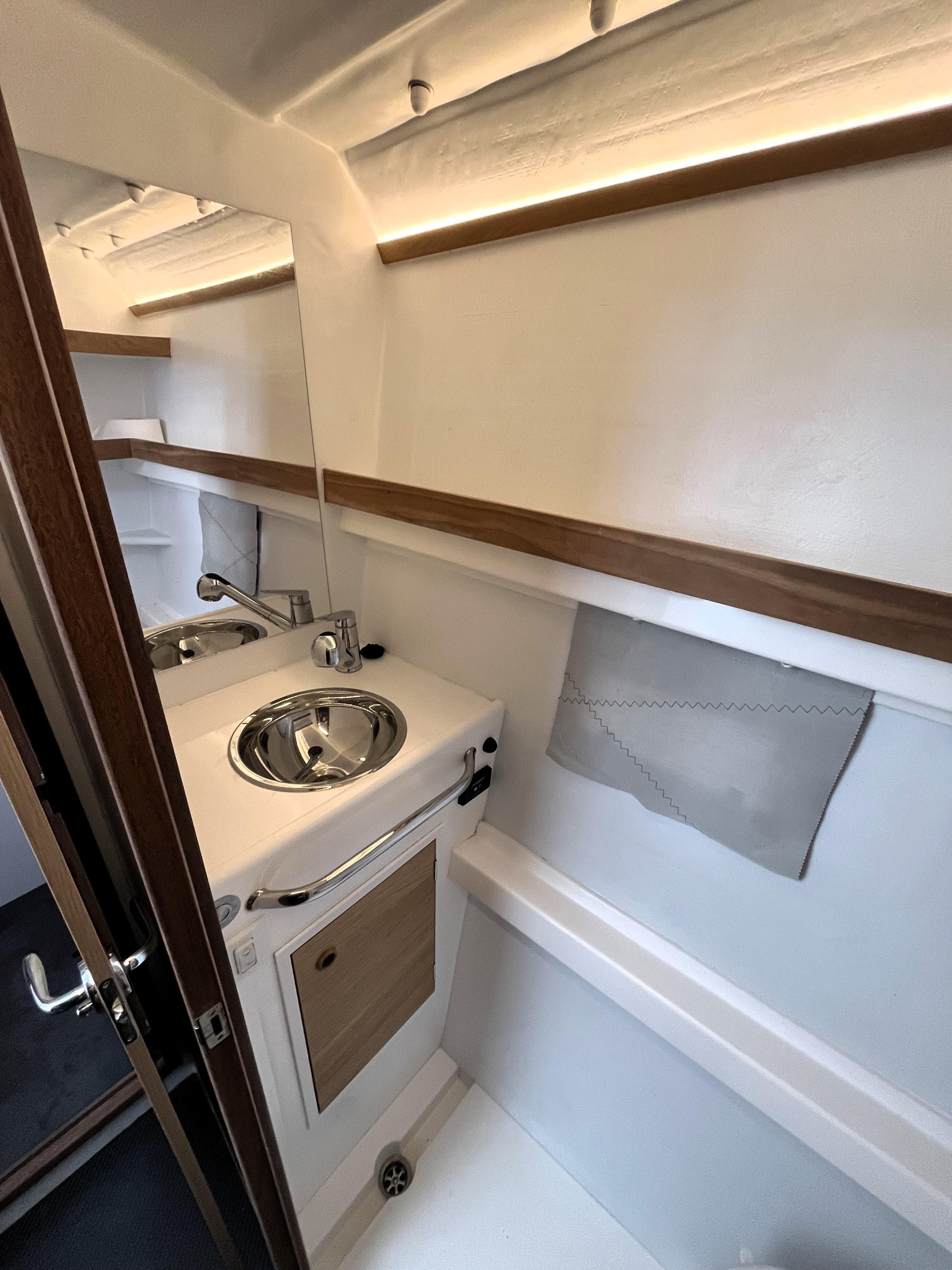 Compact bathroom in 2021 Marsaudon Composites ORC 50 yacht, featuring modern sink and storage.