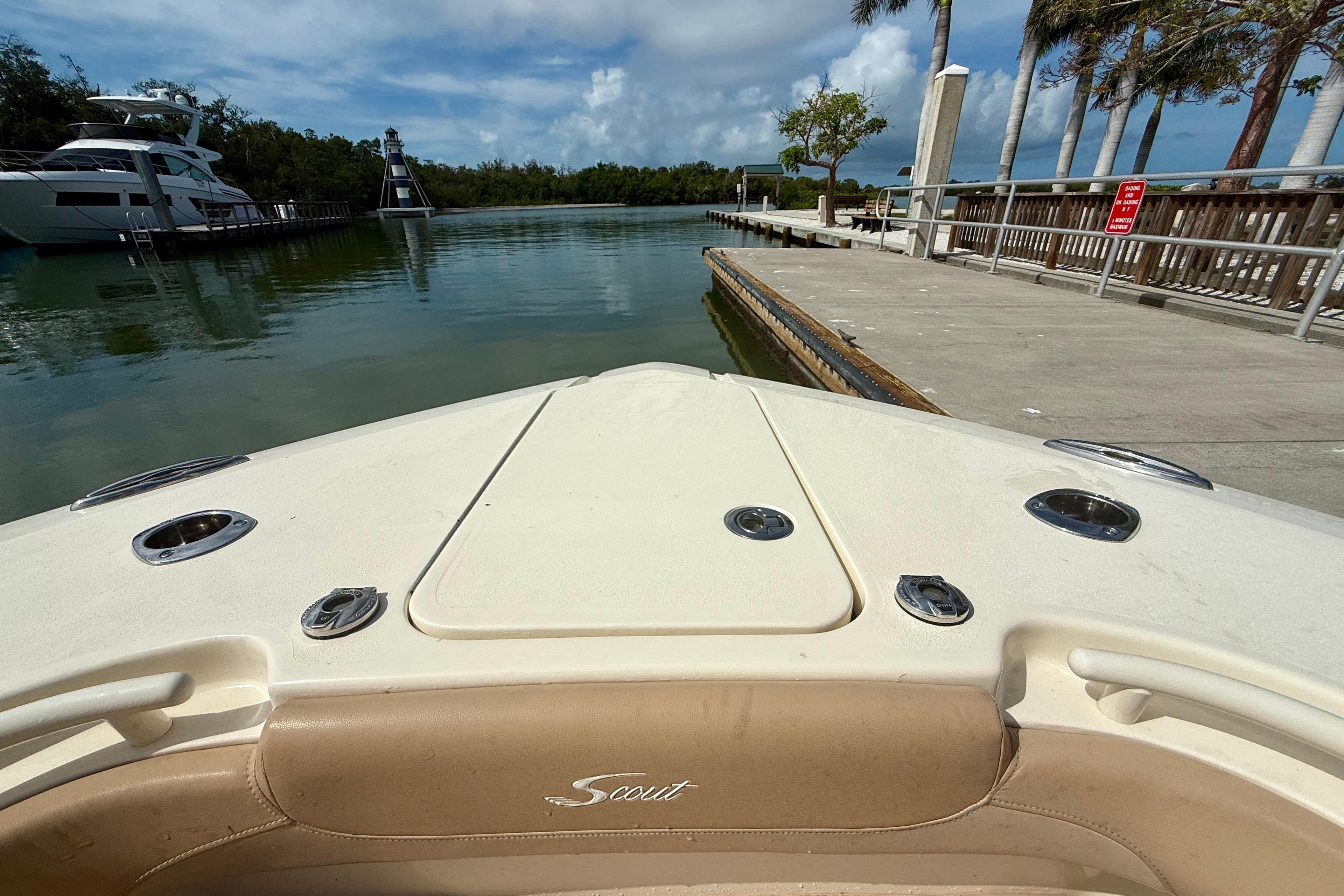 2019 Scout 275 LXF boat docked near a marina with clear skies.