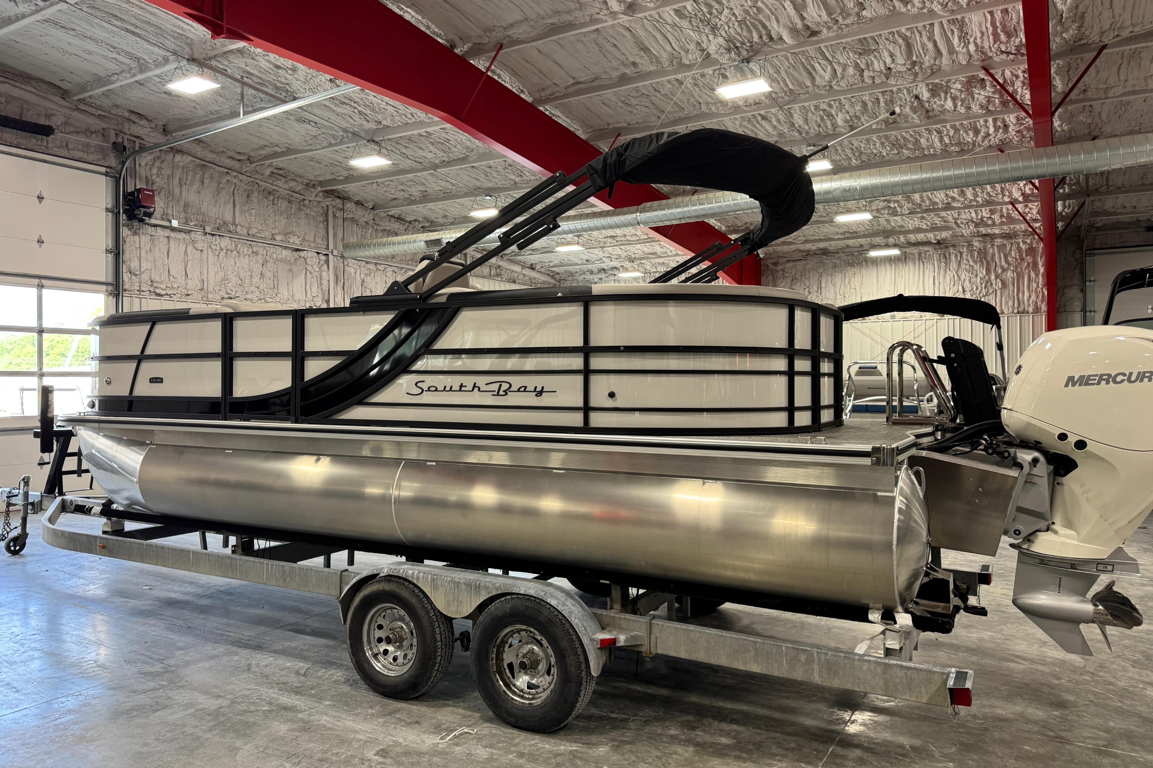 2026 South Bay 222RS LE pontoon boat on trailer in indoor storage facility.