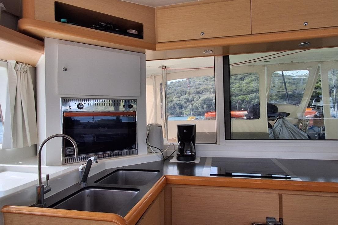 Interior of 2012 Lagoon 400 catamaran kitchen with modern appliances and scenic window view.