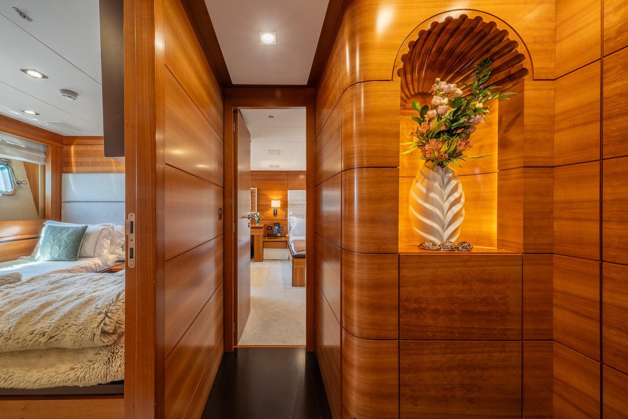 Luxurious interior of 2011 Guy Couach 121' yacht with elegant wood paneling and floral decor.
