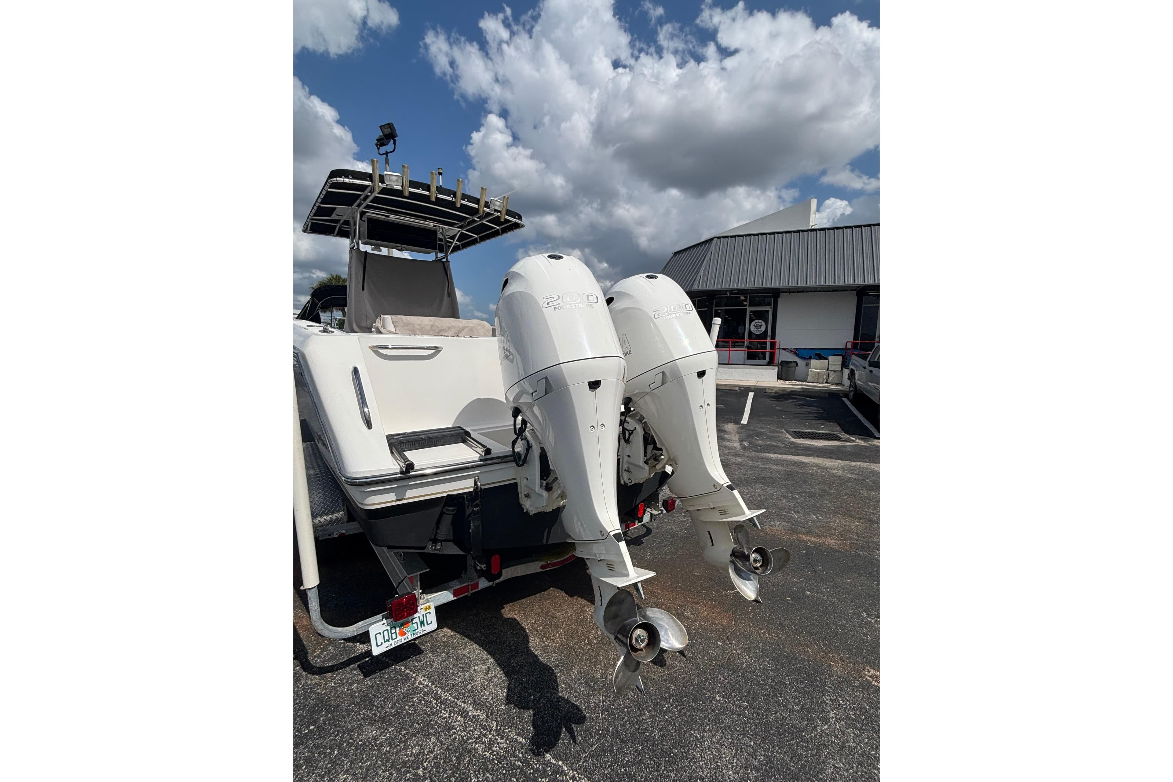 2003 Stamas 270 Tarpon boat with dual outboard engines in a parking lot.