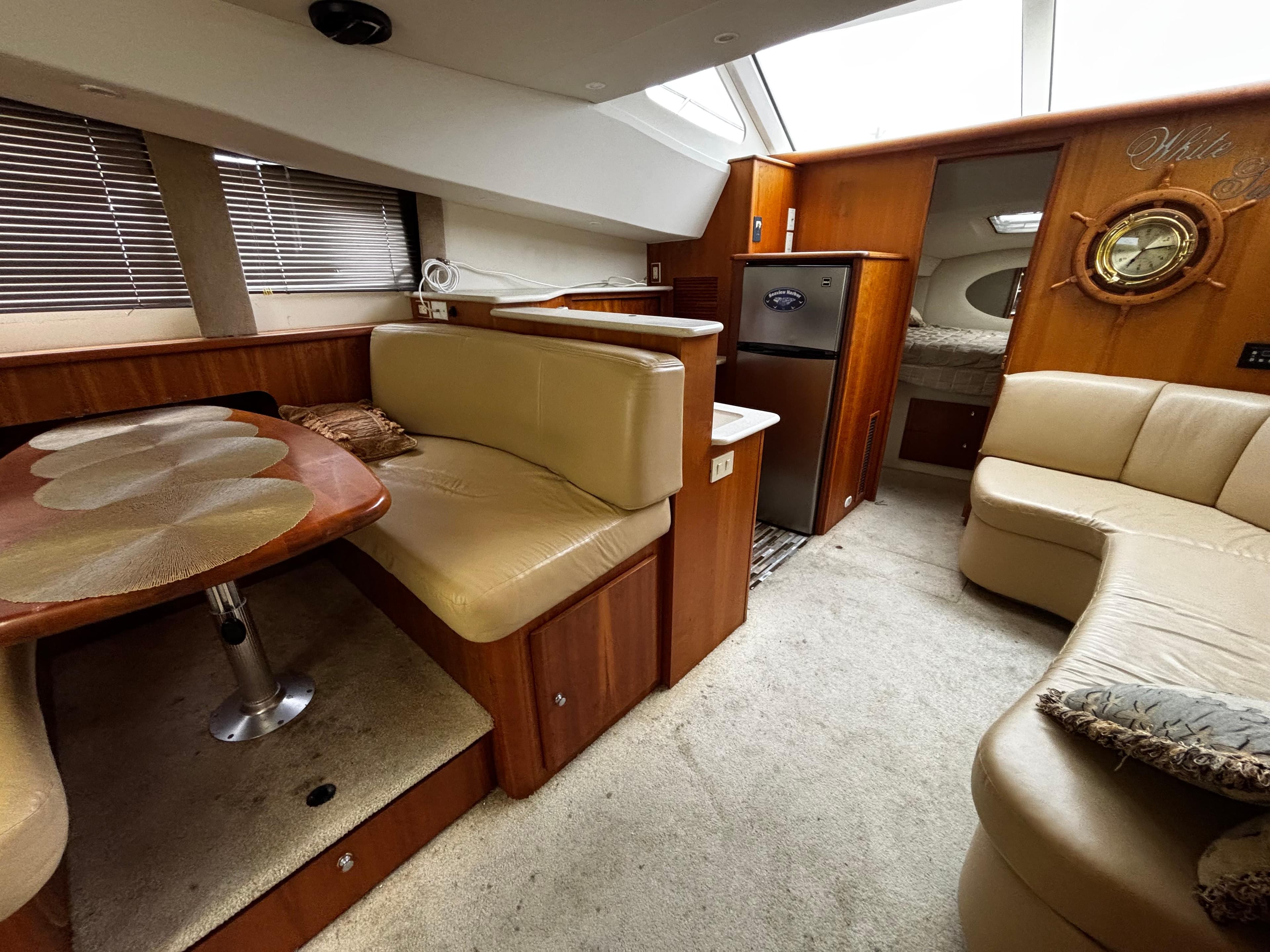 2002 Silverton 330 Sport Bridge interior with beige seating, dining area, and compact kitchen.