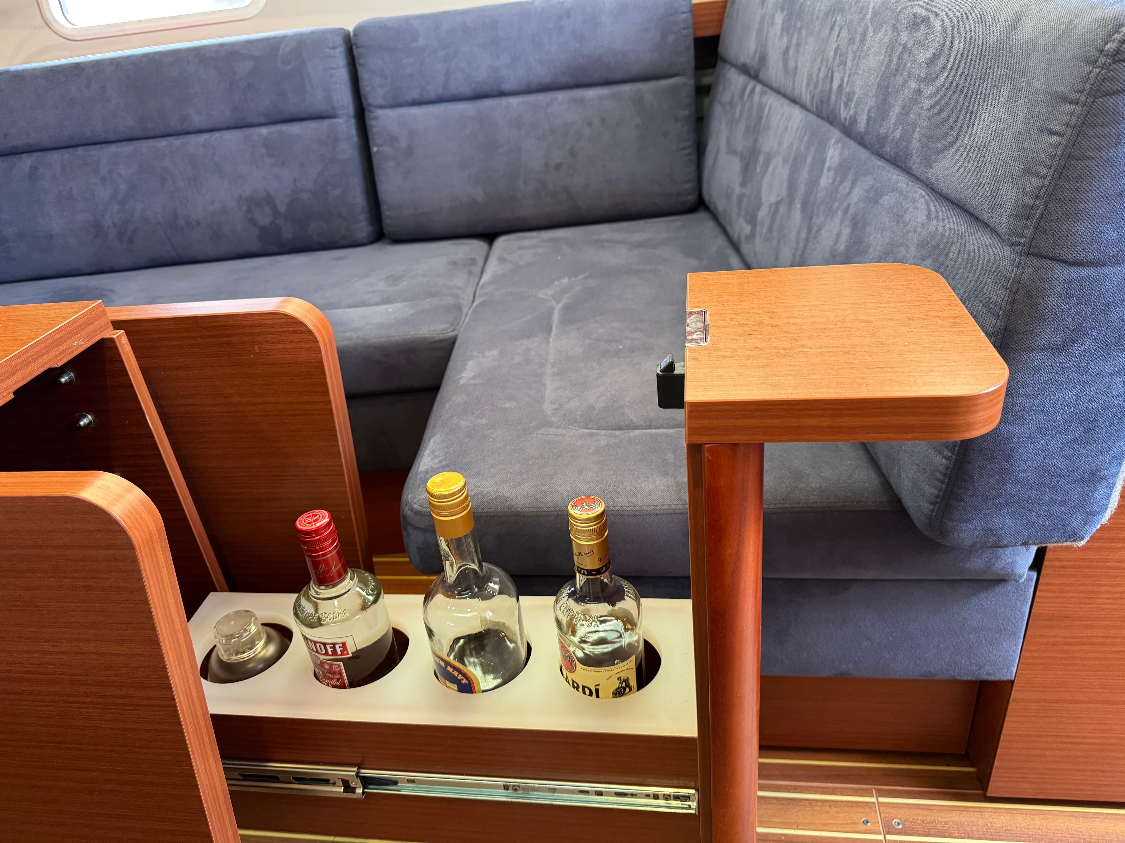 Interior of 2018 Hanse 348 yacht with built-in bottle storage and blue seating.