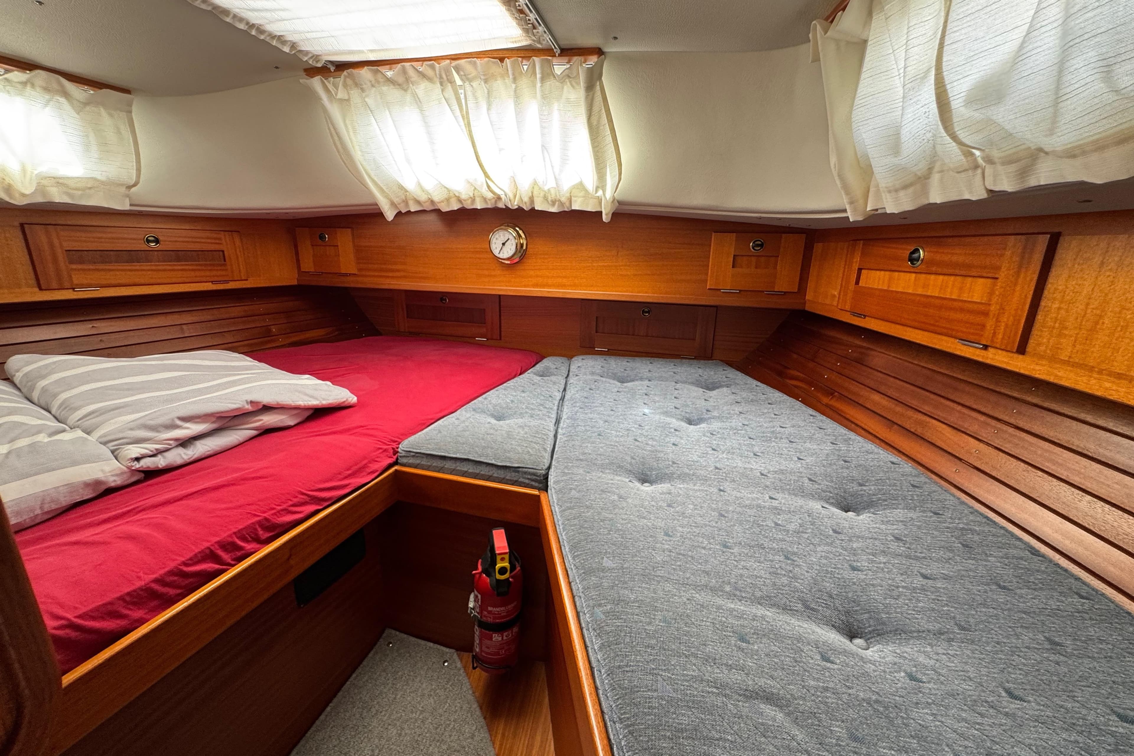 Cozy cabin interior of 1997 Hallberg-Rassy 36 MKII sailboat with wooden finish and twin beds.