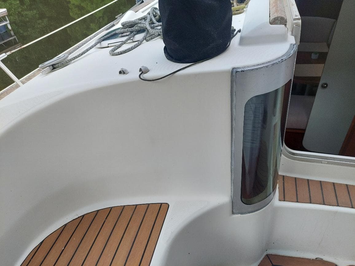 Beneteau Oceanis 351 sailboat deck, 1995 model, featuring teak flooring and cabin entrance.