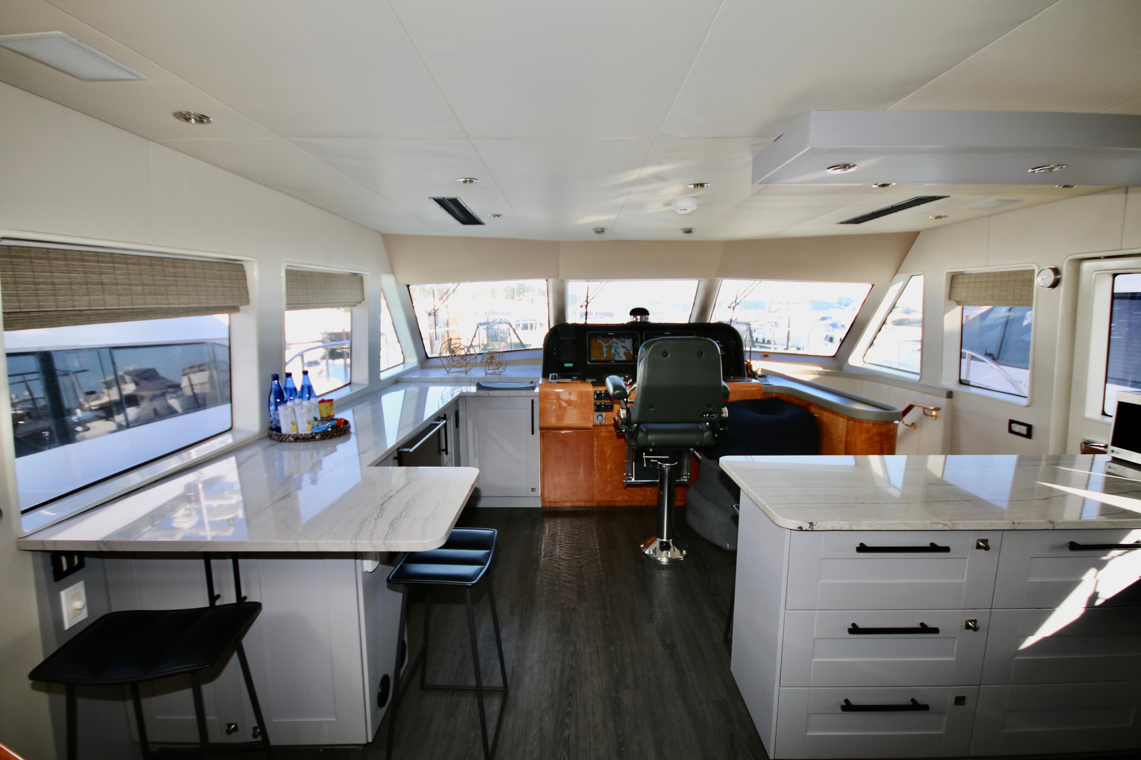 Luxurious interior of 2002 Cheoy Lee 66 Pilothouse yacht with modern helm and seating area.