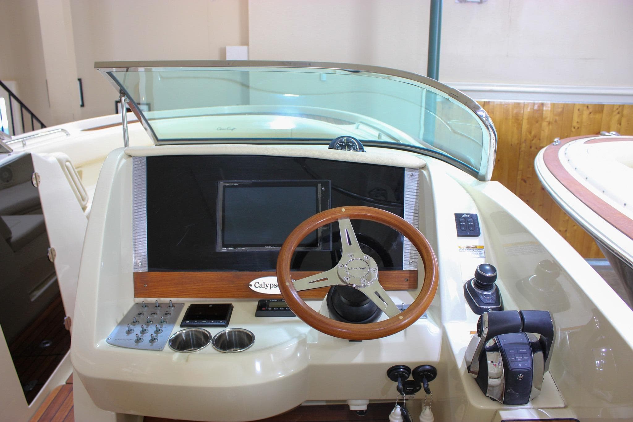 2018 Chris-Craft Calypso 30 helm with wooden steering wheel and modern controls.