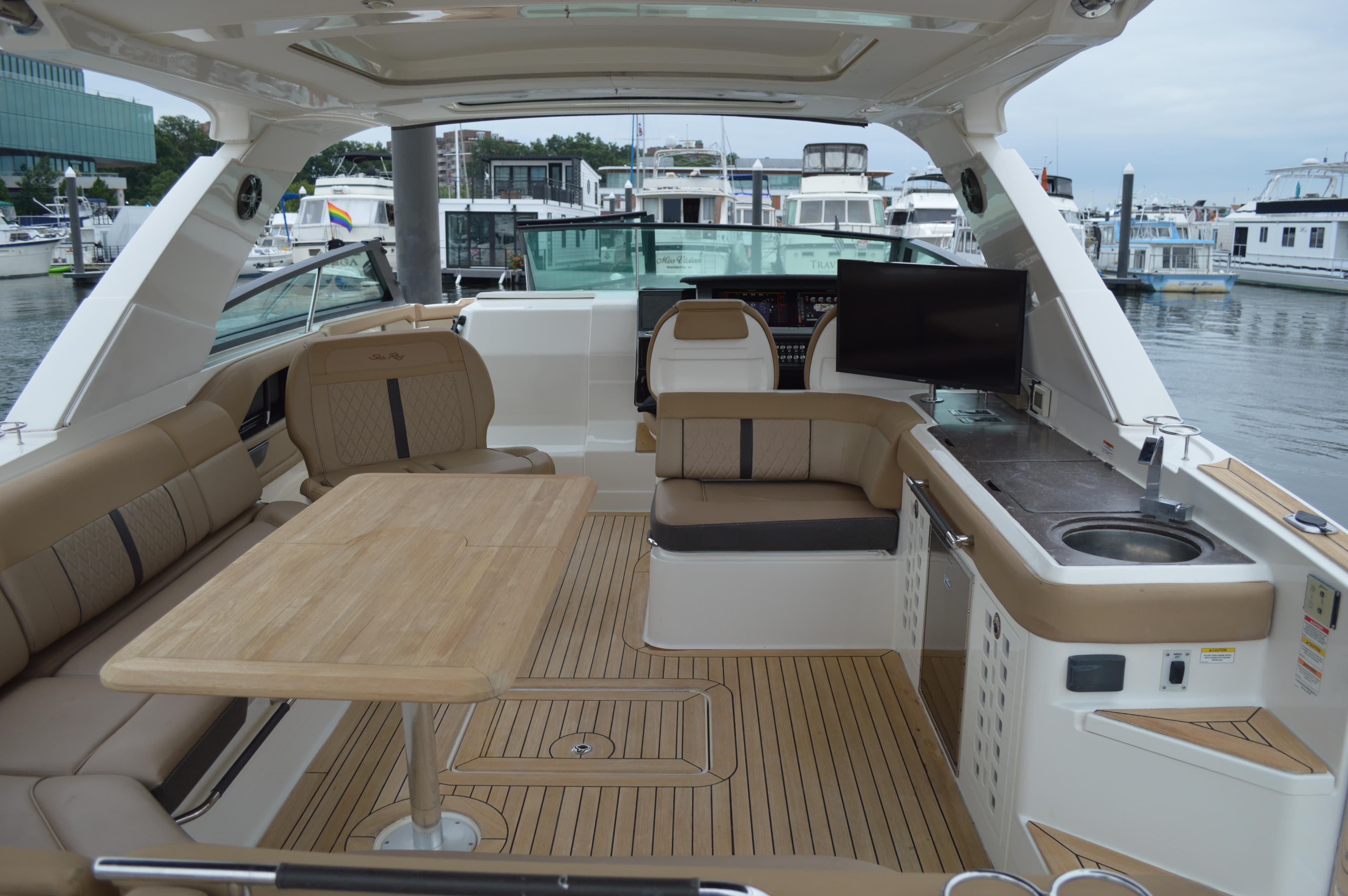 Luxurious 2019 Sea Ray SLX 400 Outboard interior with seating, table, and kitchenette.