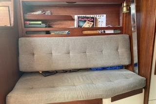 1985 Tartan 28 Piper interior with cushioned seating and wooden shelving.