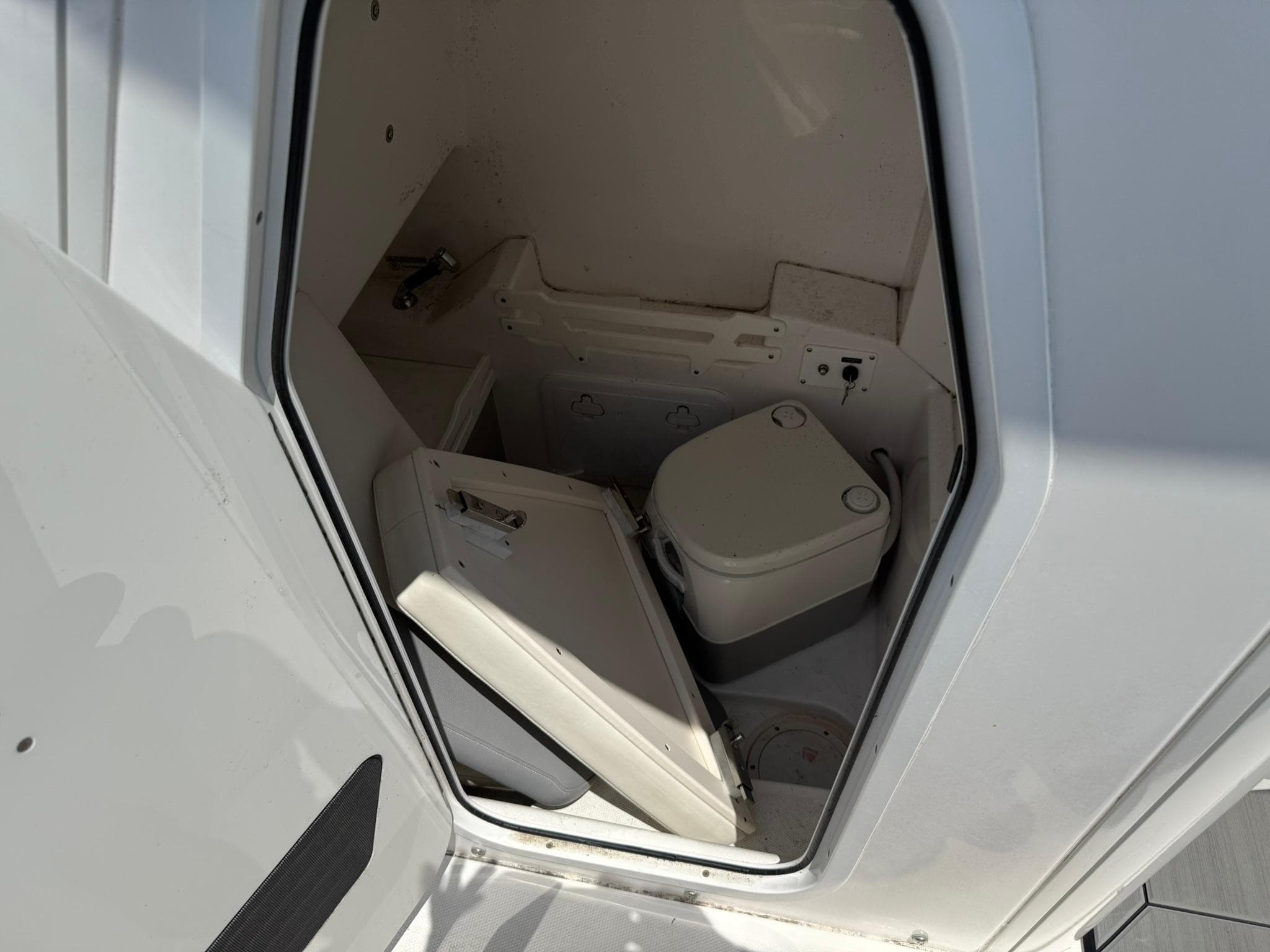 Interior of 2018 Everglades 255 Center Console boat with compact marine toilet.