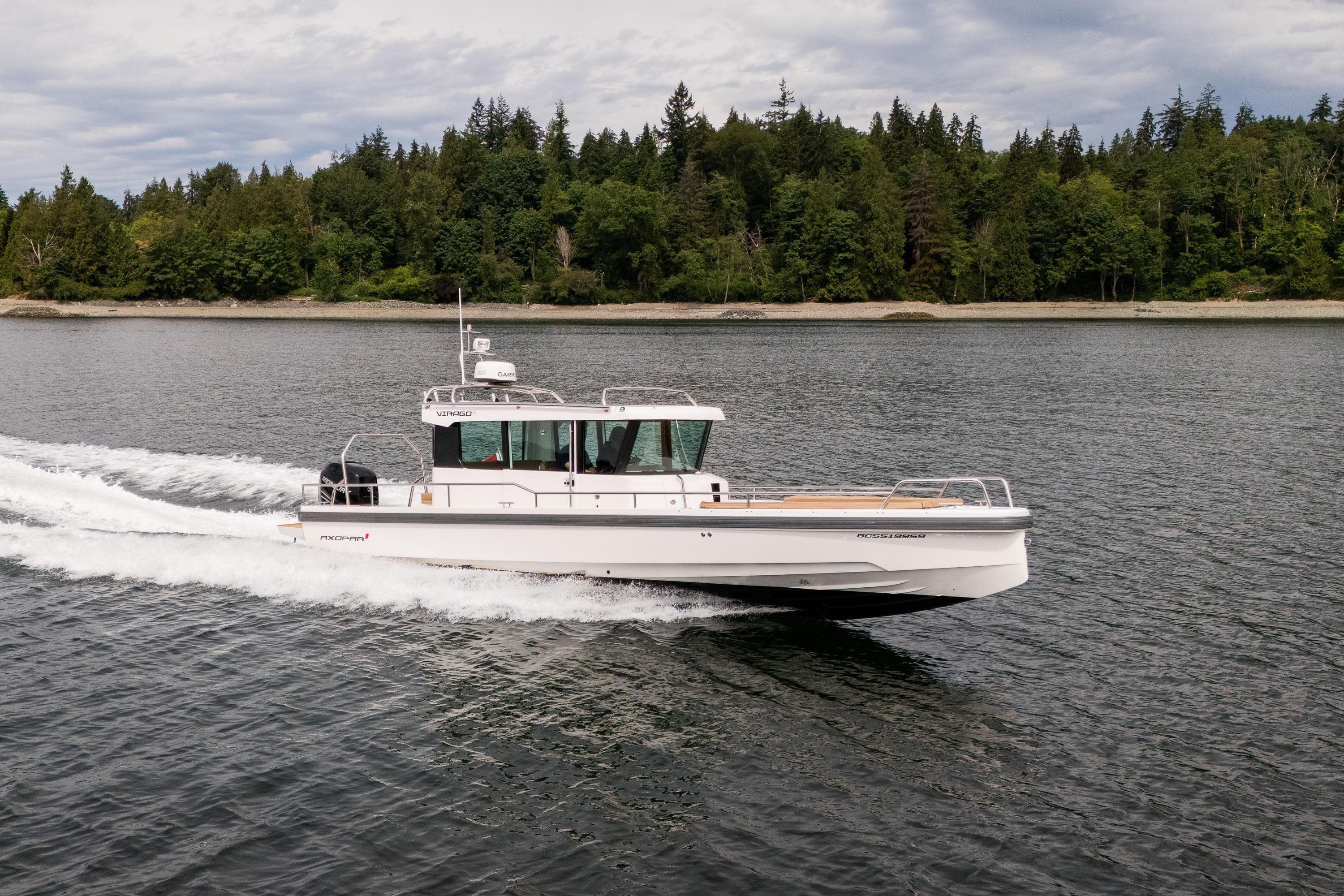 2016 Axopar 28 Cabin cruising on a serene lake with forested shoreline.