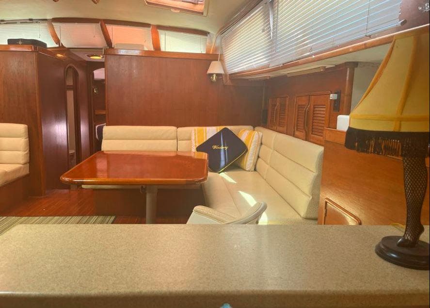 Interior of 1990 Irwin 54 yacht with wooden finishes and cozy seating area.