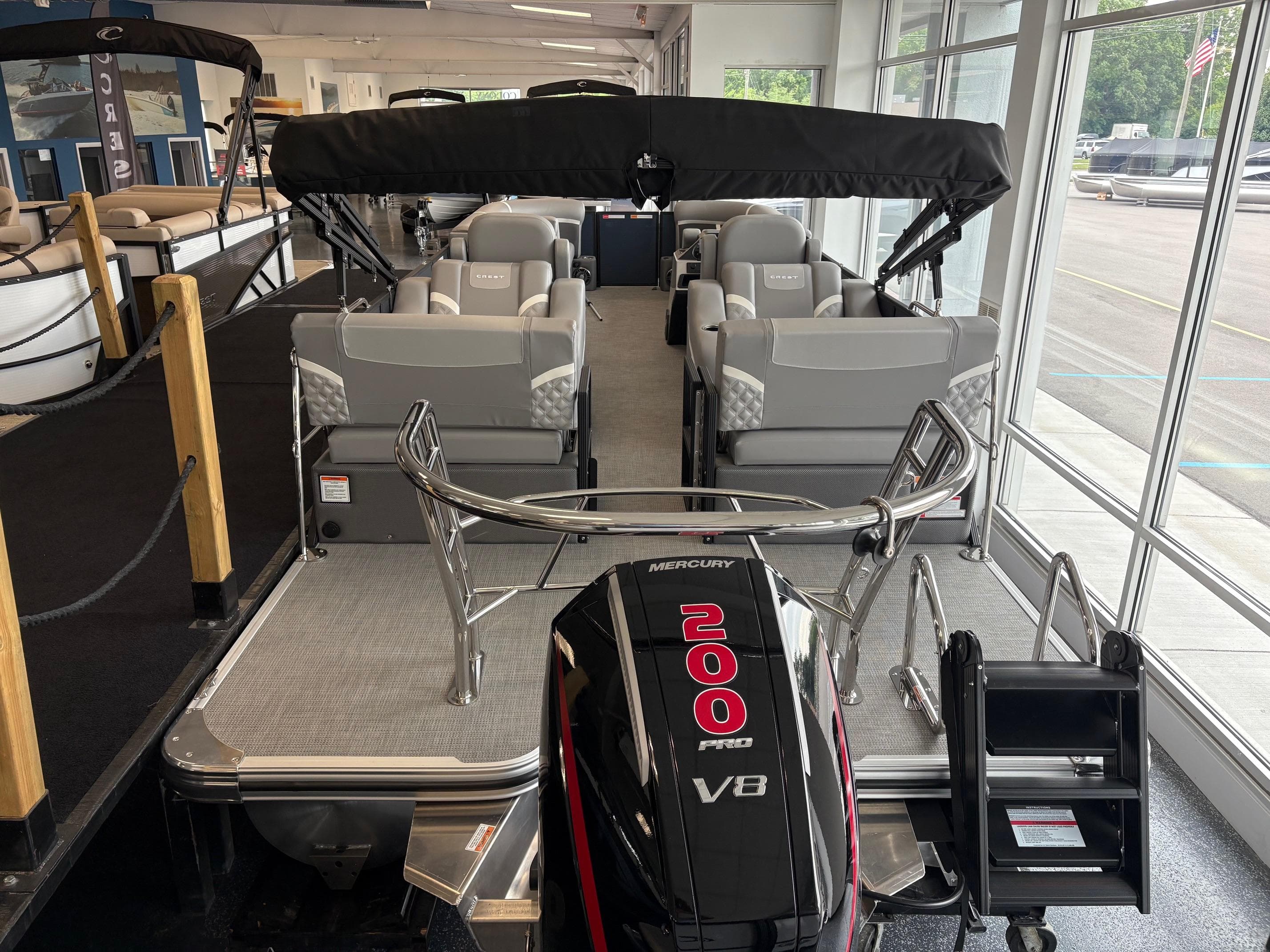 2025 Crest 240 SLRC pontoon boat with Mercury 200 V8 engine in showroom.