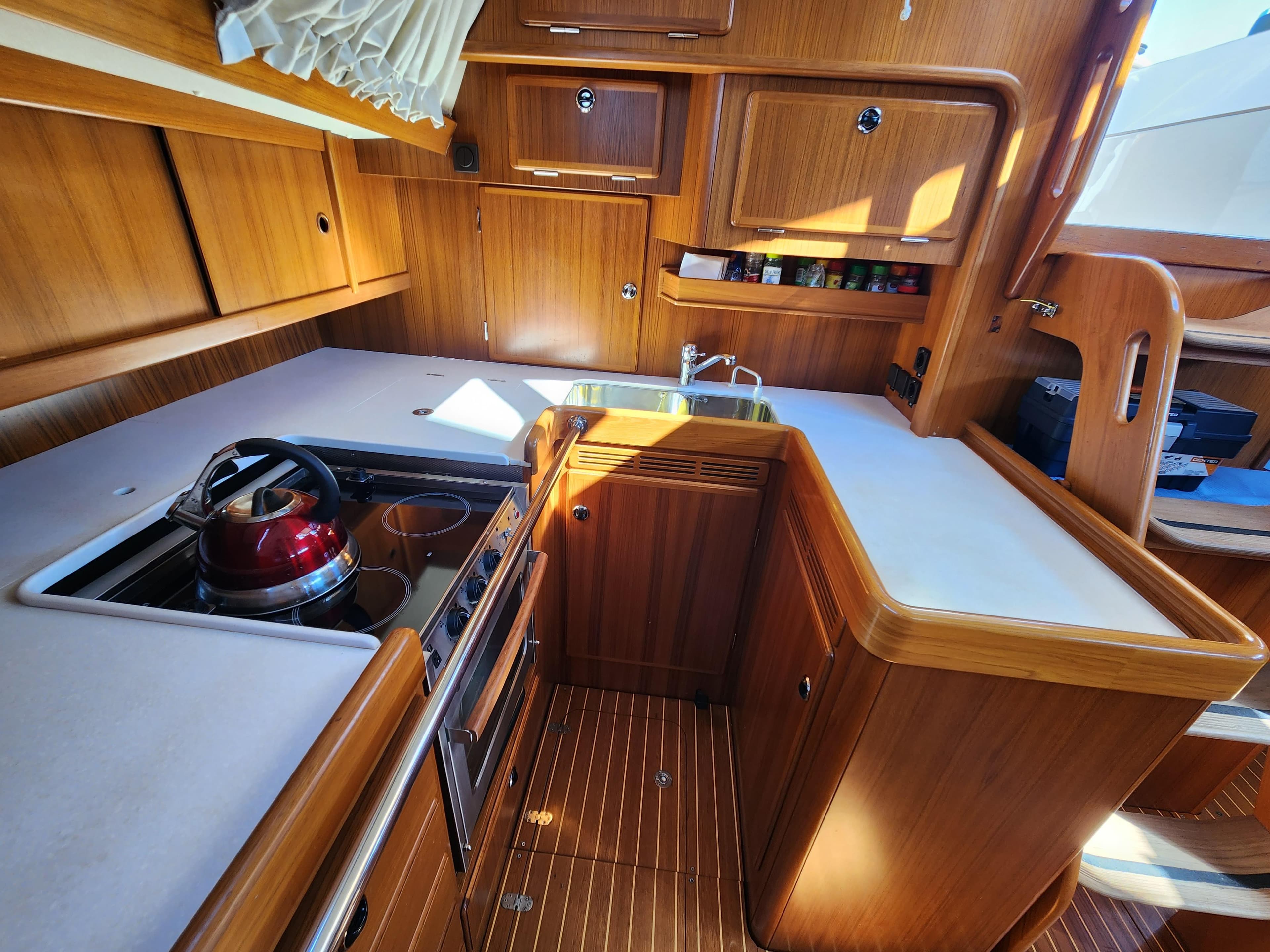Luxurious 2006 Hallberg-Rassy 53 yacht kitchen with wooden cabinetry and modern appliances.
