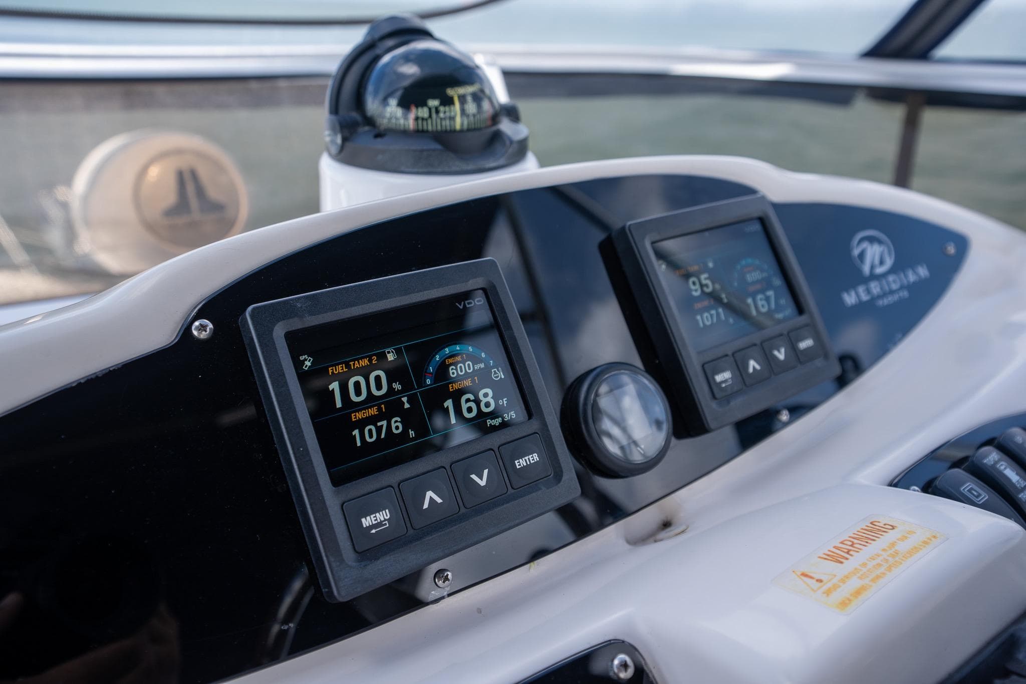 Dashboard of a 2009 Meridian 391 Sedan boat with digital displays and compass.