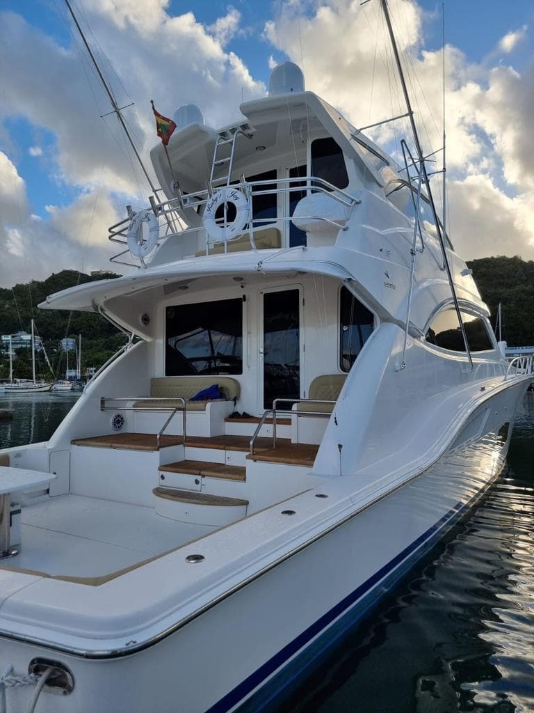 2009 Bertram 700 Enclosed yacht docked at marina with scenic background.