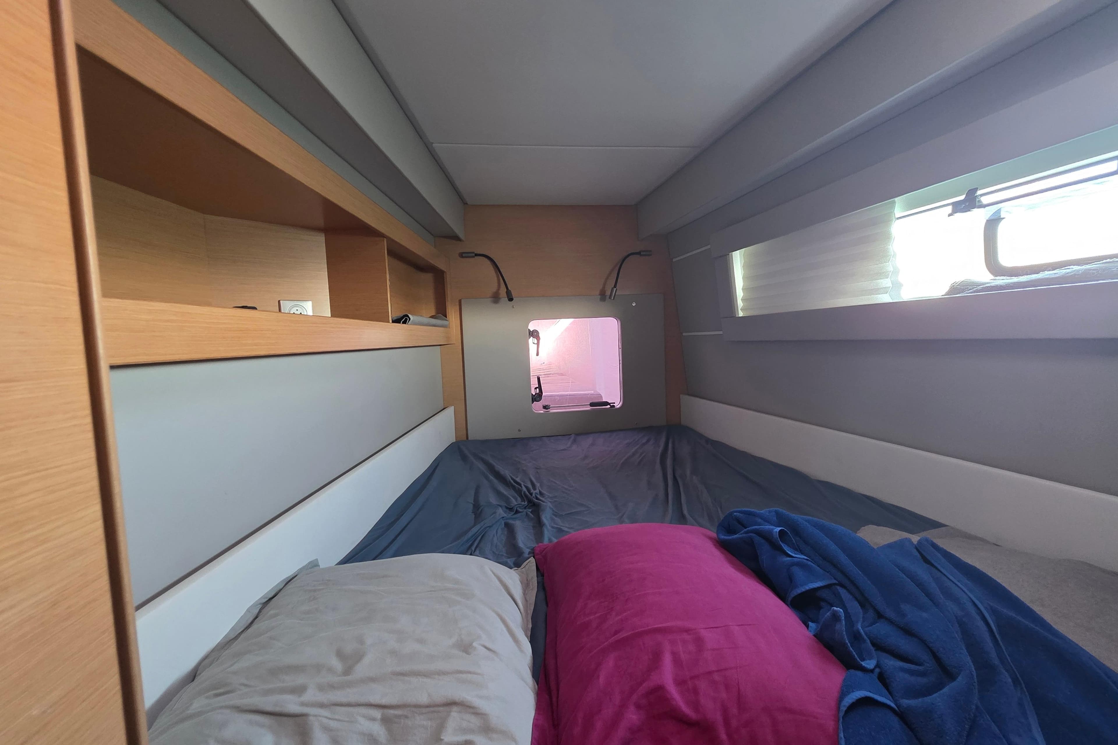 Cozy cabin interior of 2019 Nautitech 46 Open catamaran with bed and window.