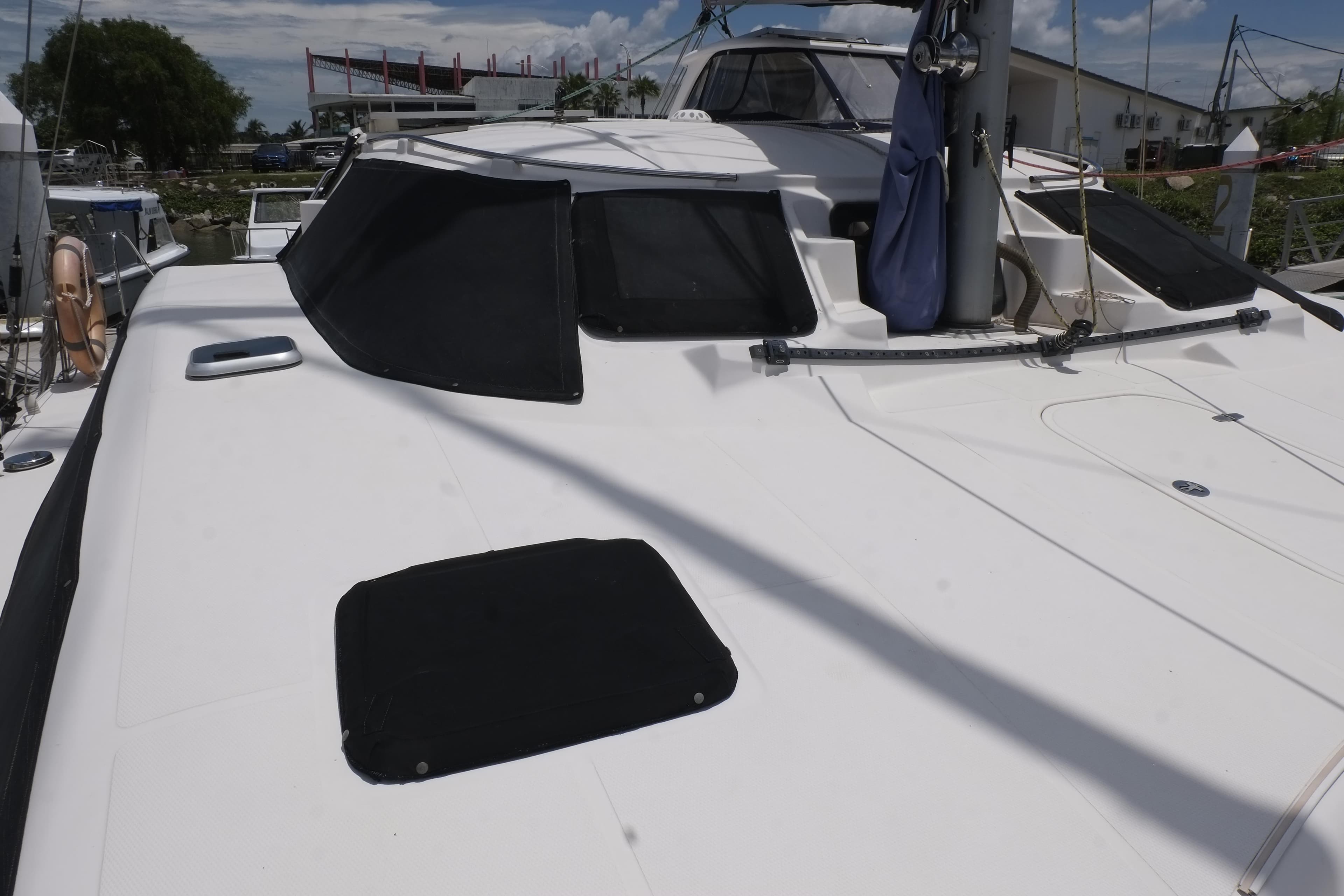 2007 Lightwave 38 catamaran with sleek white deck and tinted windows.
