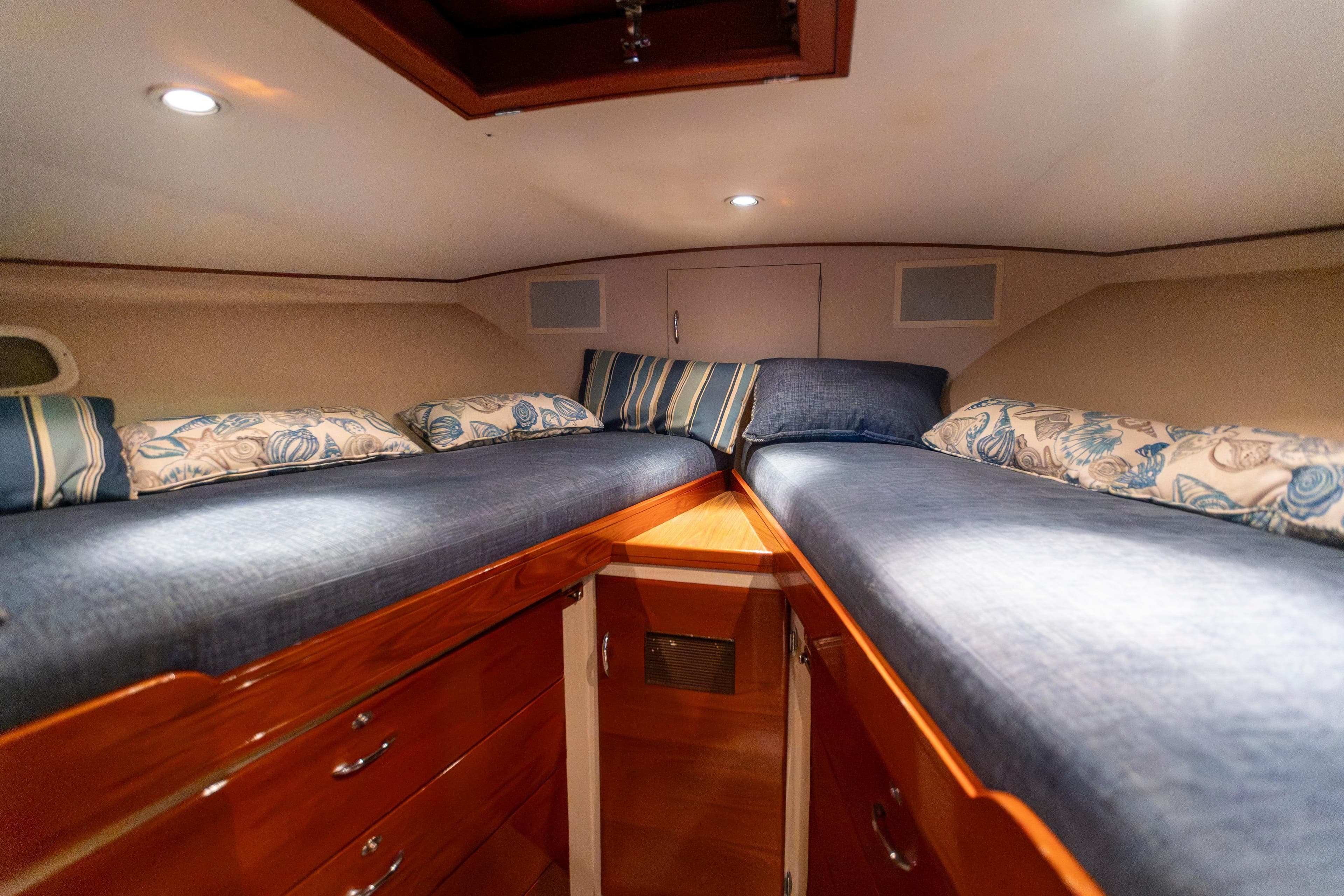 1972 Rybovich Convertible cabin interior with twin beds and wooden cabinetry.