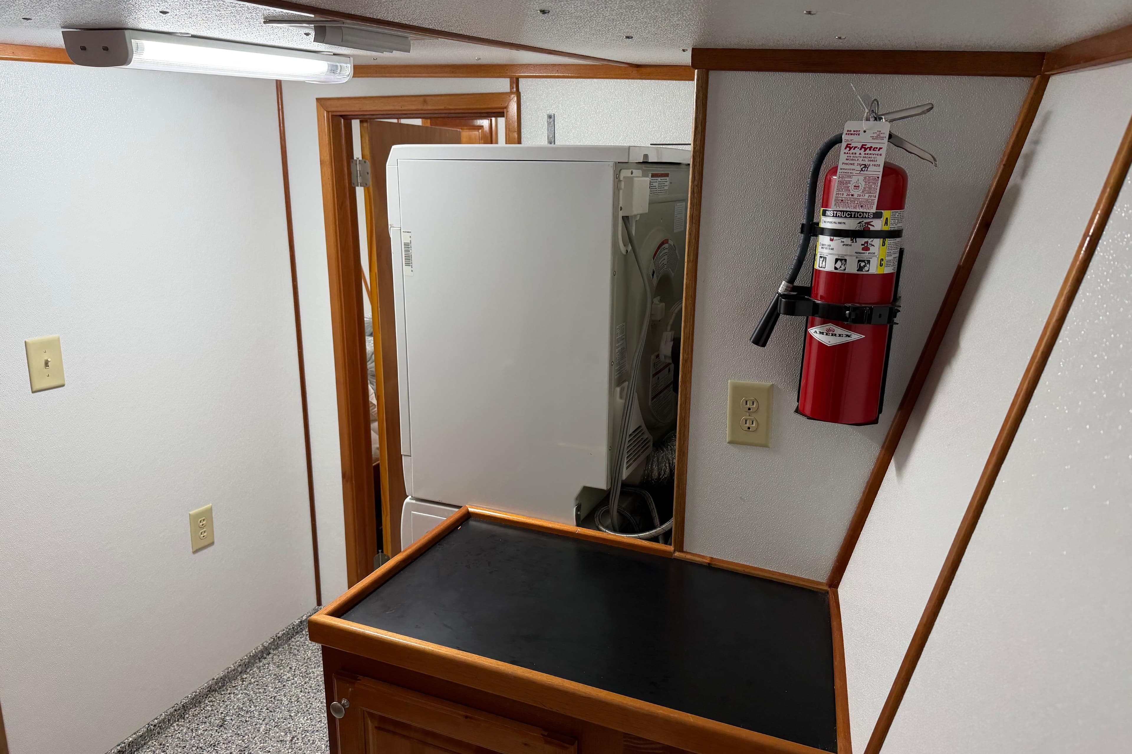 Interior of a 1954 American 70 Tug with fire extinguisher and laundry area.