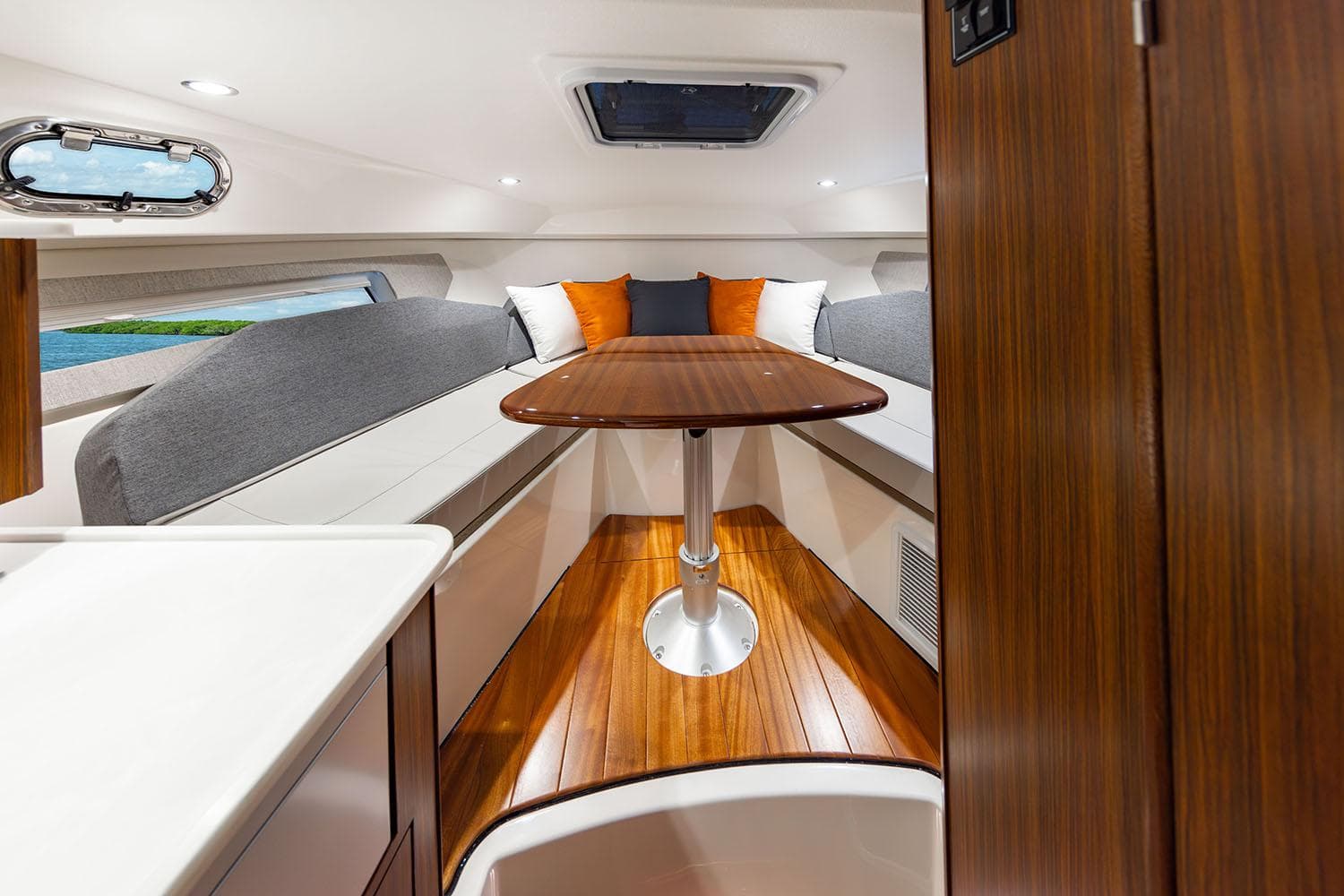 Manufacturer Provided Image: 2025 Pursuit OS 325 Offshore cabin interior with wood table and cushioned seating.