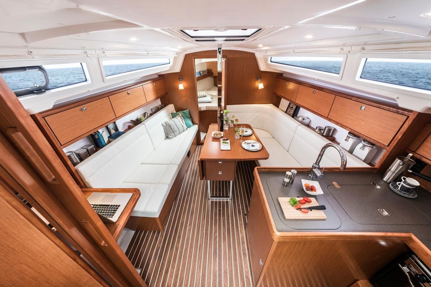 Luxurious interior of 2026 Bavaria Cruiser 34 yacht with modern kitchen and seating area.