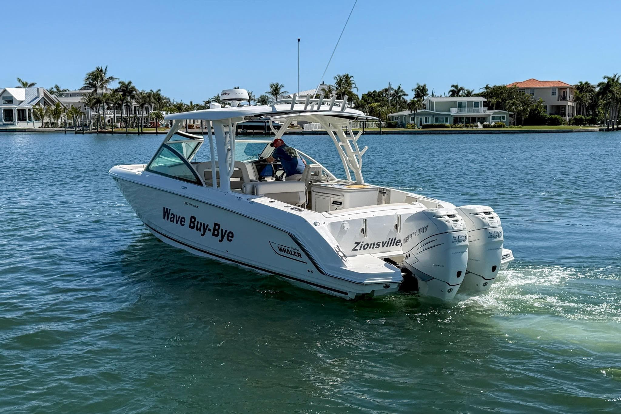 2017 Boston Whaler 320 Vantage boat cruising on a sunny day near waterfront homes.