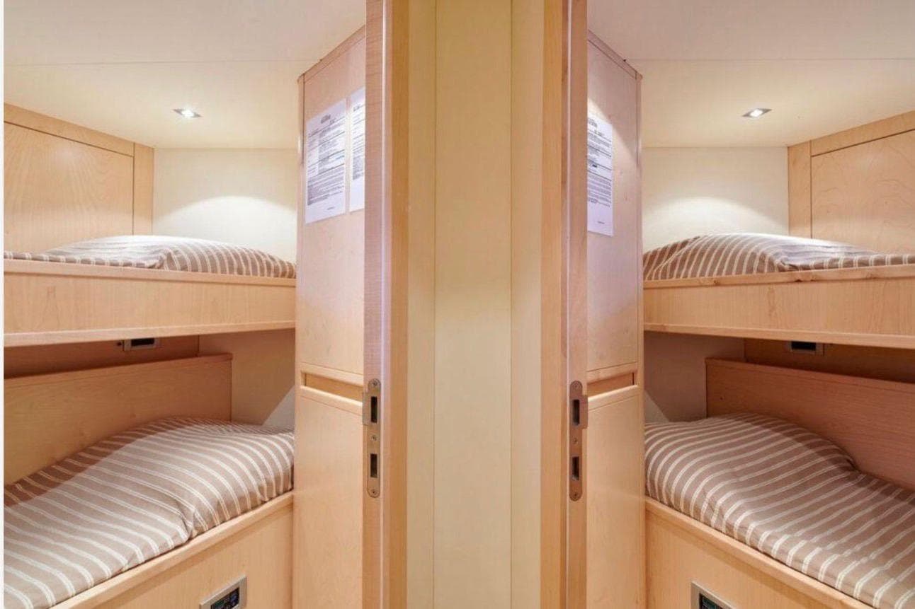 Compact wooden bunk beds in a Custom Line 97 yacht, 2010 model.