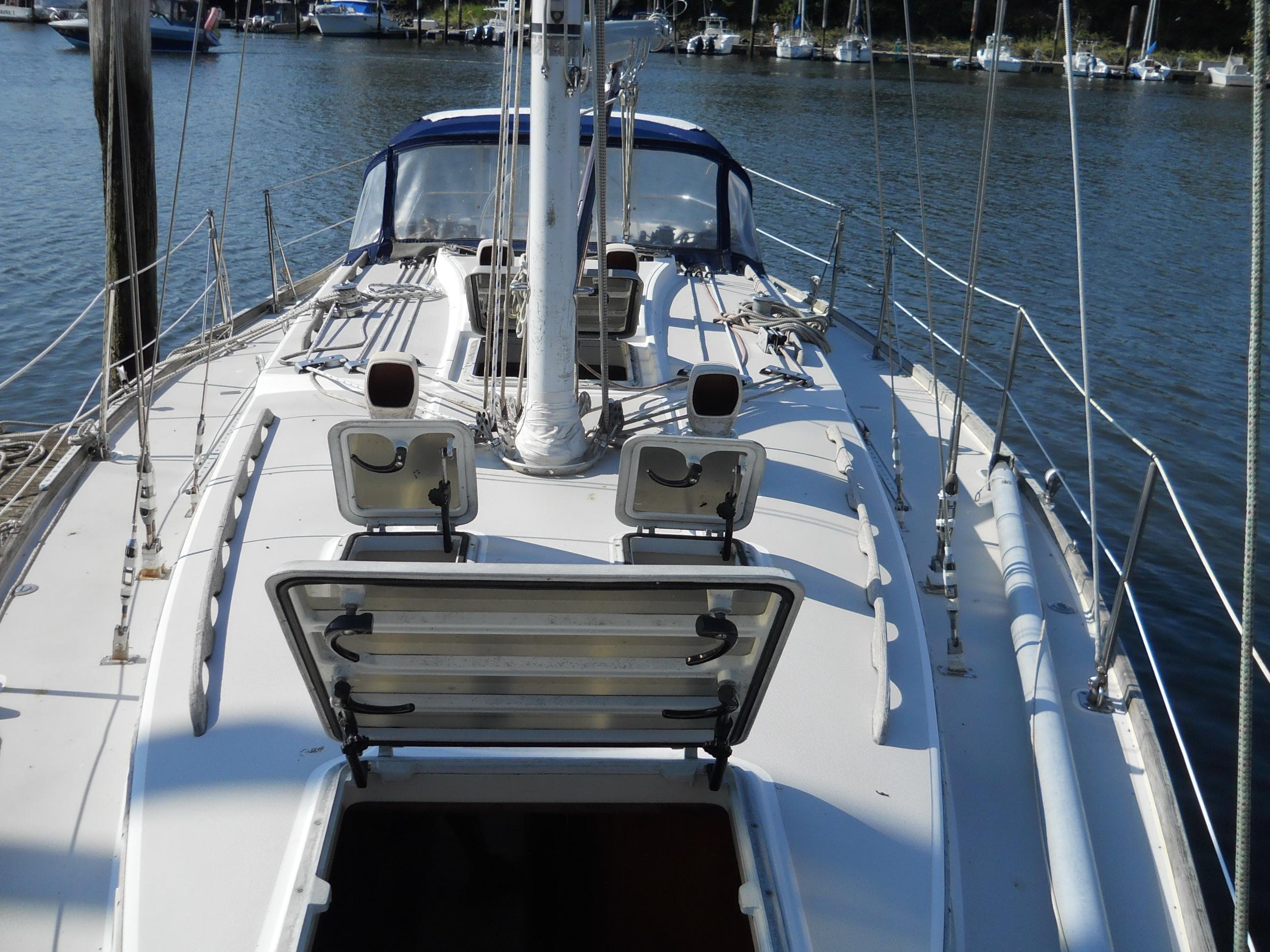 1985 Sabre 38 MK I sailboat deck with open hatch, docked in marina.