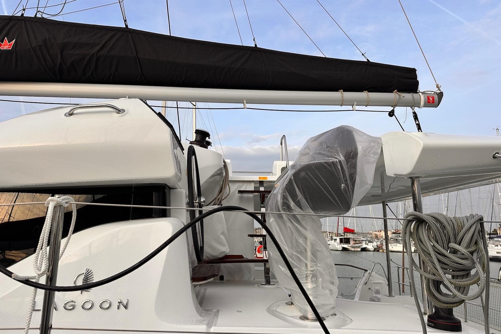 2026 Lagoon 43 yacht deck with wrapped equipment and coiled ropes in marina.