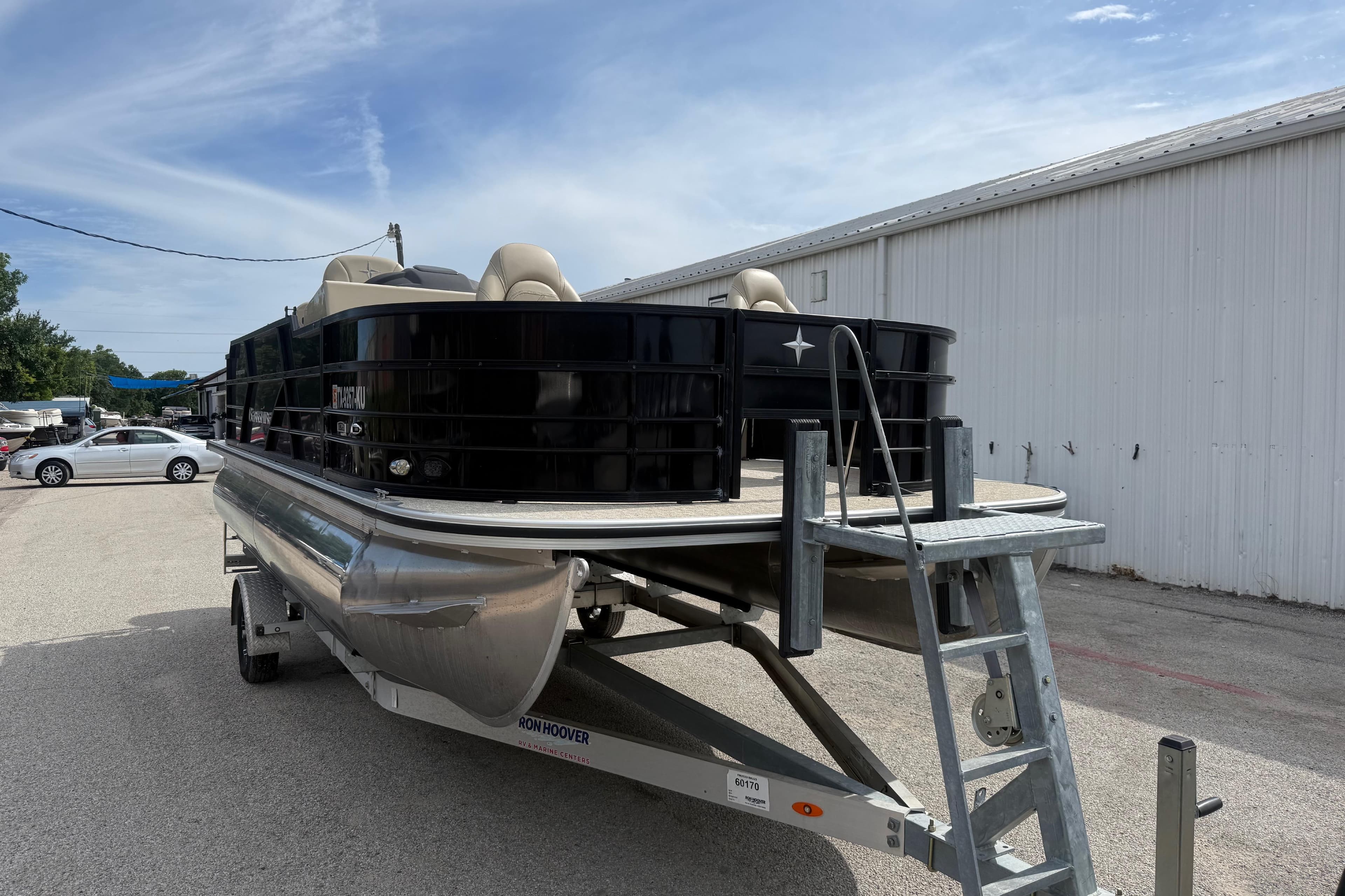 2023 Berkshire 20A CTS pontoon boat on trailer, parked outdoors near a white building.